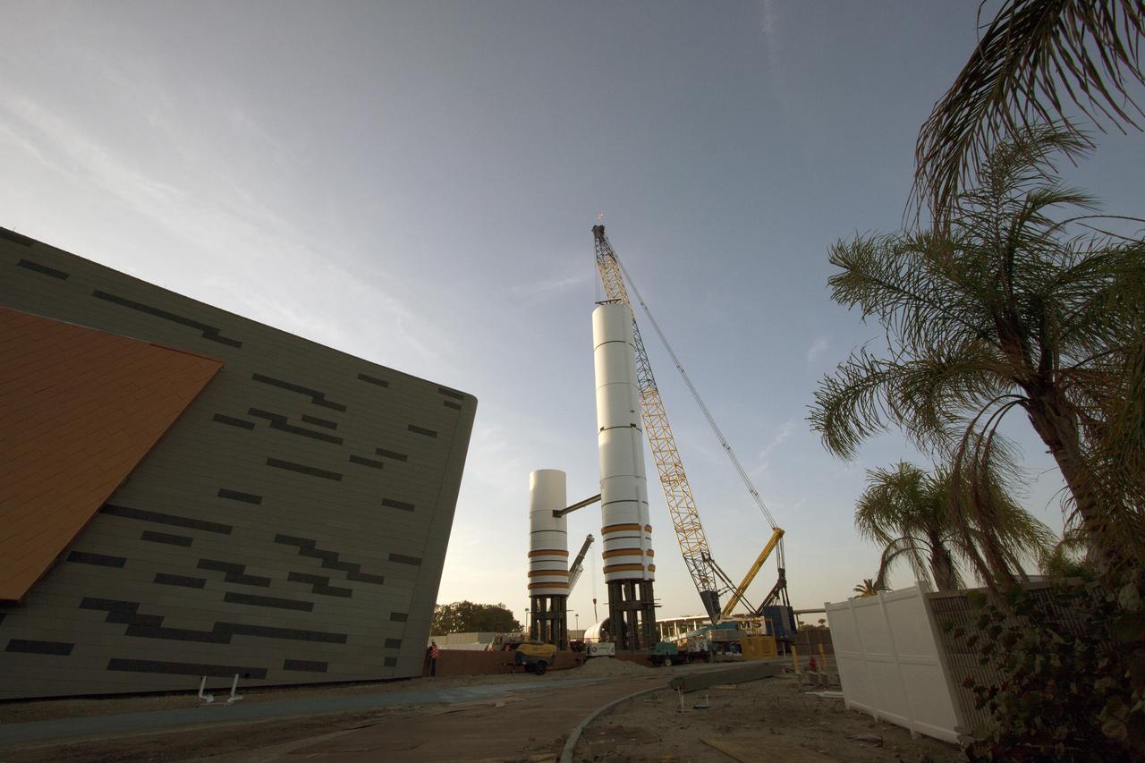 CAPE CANAVERAL, Fla. – Workers prepare to lift a segment for a set of twin, full-size replica Solid Rocket Boosters SRBs in front of the Space Shuttle Atlantis exhibit under construction at the Kennedy Space Center Visitor Complex in Florida. Atlantis is housed in the building behind the SRB stack. An external tank replica will be added later to the middle of the SRBs to complete the display. The SRBs stand 150 feet tall, while the external tank will reach 184 feet when it is finished. The shuttle was mounted to the stack and depended on the power of the SRBs to lift it off the launch pad and start it on its way to space. The external tank was loaded with liquid propellants for the shuttle's three main engines. Photo credit: NASA_Jim Grossmann