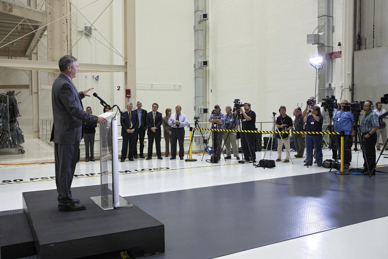CAPE CANAVERAL, Fla. – In the Operations and Checkout Building OandC at the Kennedy Space Center in Florida, Scott Colloredo, chief architect for the Ground Systems Development and Operations Program, speaks to news media representatives updating progress on preparing the Orion spacecraft for its first uncrewed mission, Exploration Flight Test-1 EFT-1 in 2014. The crew module is seen behind Hefner in its test stand. Launched atop NASA's heavy-lift Space Launch System rocket, Orion is now targeted to take astronauts in a sample return mission to an asteroid as early as 2021. On the third anniversary of President Barack Obama issuing his challenge to NASA to send astronauts to an asteroid, news media representatives were given an opportunity to see up-close the Orion spacecraft which could take astronauts on such a flight. They also heard from key leaders of that effort in Kennedy's OandC where Orion's assembly is taking place. Photo credit: NASA_Kim Shiflett