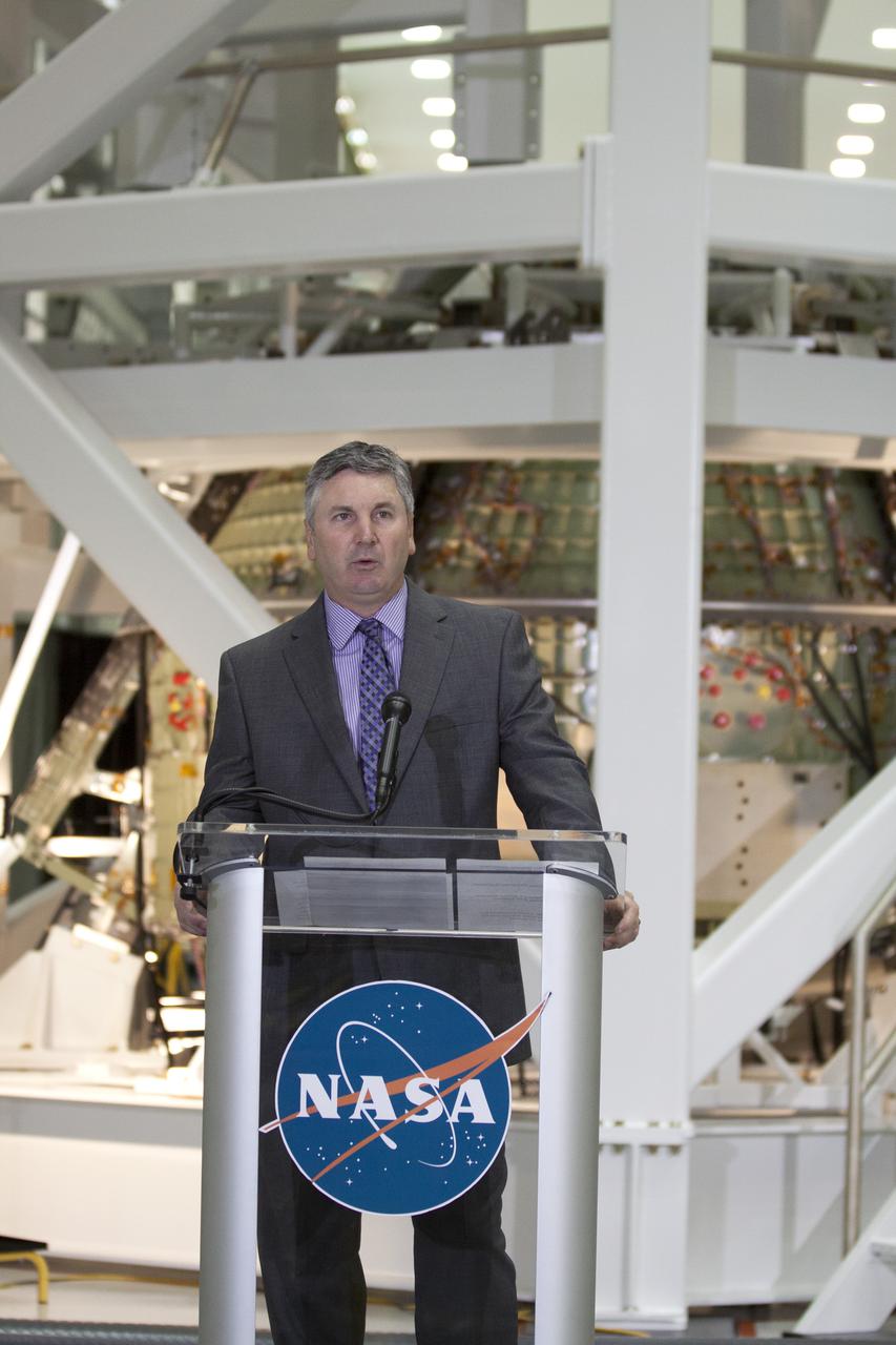 CAPE CANAVERAL, Fla. – In the Operations and Checkout Building OandC at the Kennedy Space Center in Florida, Scott Colloredo, chief architect for the Ground Systems Development and Operations Program, speaks to news media representatives updating progress on preparing the Orion spacecraft for its first uncrewed mission, Exploration Flight Test-1 EFT-1 in 2014. The crew module is seen behind Hefner in its test stand. Launched atop NASA's heavy-lift Space Launch System rocket, Orion is now targeted to take astronauts in a sample return mission to an asteroid as early as 2021. On the third anniversary of President Barack Obama issuing his challenge to NASA to send astronauts to an asteroid, news media representatives were given an opportunity to see up-close the Orion spacecraft which could take astronauts on such a flight. They also heard from key leaders of that effort in Kennedy's OandC where Orion's assembly is taking place. Photo credit: NASA_Kim Shiflett
