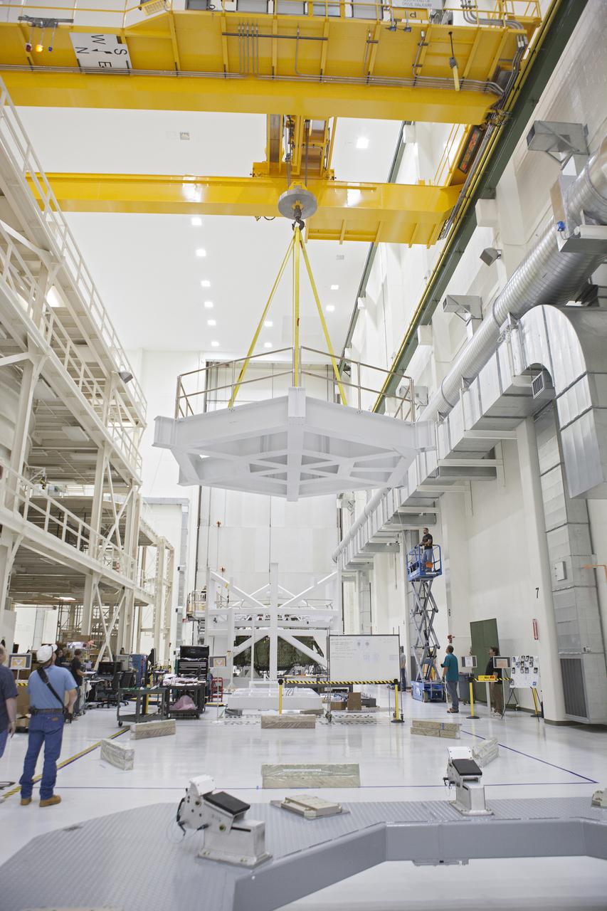 CAPE CANAVERAL, Fla. – Inside the Operations and Checkout Building high bay at NASA’s Kennedy Space Center in Florida, technicians monitor the progress as a crane lifts the top platform of a test stand for the Orion crew module. Lockheed Martin Space Systems and NASA engineers are preparing Orion for a series of static load tests that simulate the massive loads the spacecraft would experience during its mission. Orion is the exploration spacecraft designed to carry crews to space beyond low Earth orbit. It will provide emergency abort capability, sustain the crew during the space travel and provide safe re-entry from deep space return velocities. Orion’s first unpiloted test flight, Exploration Flight Test 1, is scheduled to launch in 2014 atop a Delta IV rocket. A second uncrewed flight test is scheduled for 2017 on NASA’s Space Launch System rocket. For more information, visit http:__www.nasa.gov_orion. Photo credit: NASA_Gary Thompson