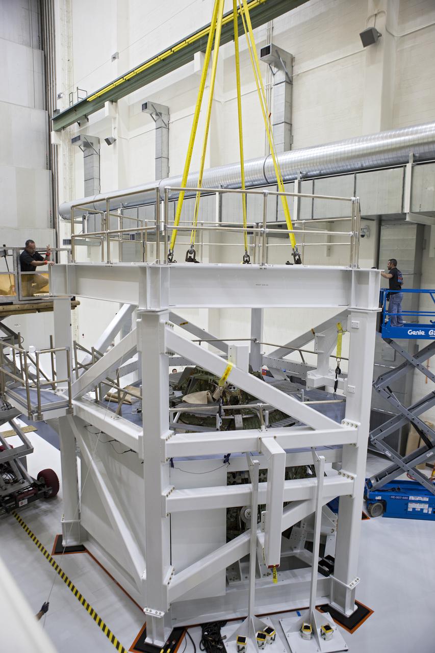 CAPE CANAVERAL, Fla. – Inside the Operations and Checkout Building high bay at NASA’s Kennedy Space Center in Florida, technicians attach the top platform to the test stand for the Orion crew module. Lockheed Martin Space Systems and NASA engineers are preparing Orion for a series of static load tests that simulate the massive loads the spacecraft would experience during its mission. Orion is the exploration spacecraft designed to carry crews to space beyond low Earth orbit. It will provide emergency abort capability, sustain the crew during the space travel and provide safe re-entry from deep space return velocities. Orion’s first unpiloted test flight, Exploration Flight Test 1, is scheduled to launch in 2014 atop a Delta IV rocket. A second uncrewed flight test is scheduled for 2017 on NASA’s Space Launch System rocket. For more information, visit http:__www.nasa.gov_orion. Photo credit: NASA_Gary Thompson