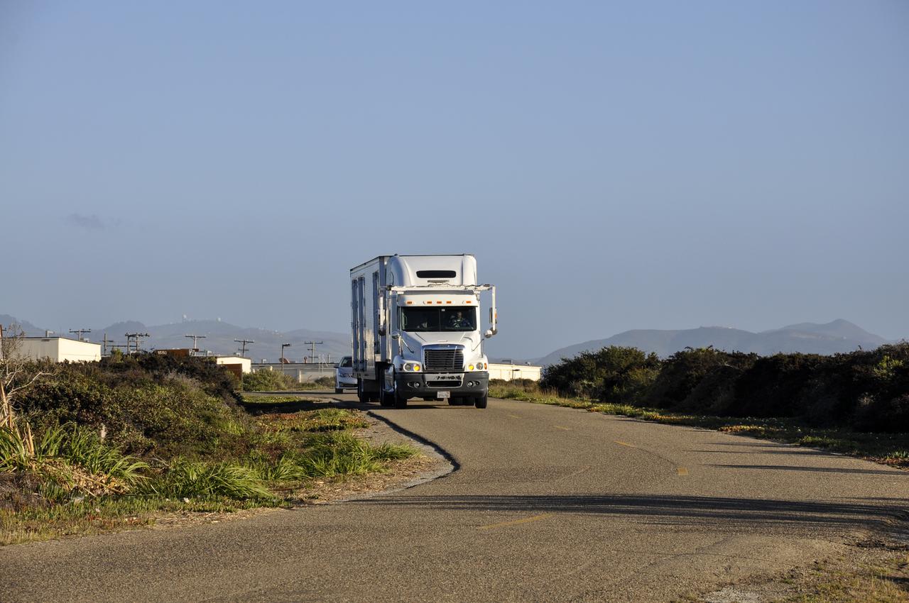 VANDENBERG AFB, Calif. – A truck carrying NASA's IRIS spacecraft nears the processing facility at Vandenberg where the spacecraft will be readied for launch aboard an Orbital Sciences Pegasus XL rocket. IRIS is short for Interface Region Imaging Spectrograph and the spacecraft's mission will improve our understanding of how heat and energy move through the deepest levels of the sun’s atmosphere, thereby increasing our ability to forecast space weather. Photo credit: VAFB_Randy Beaudoin
