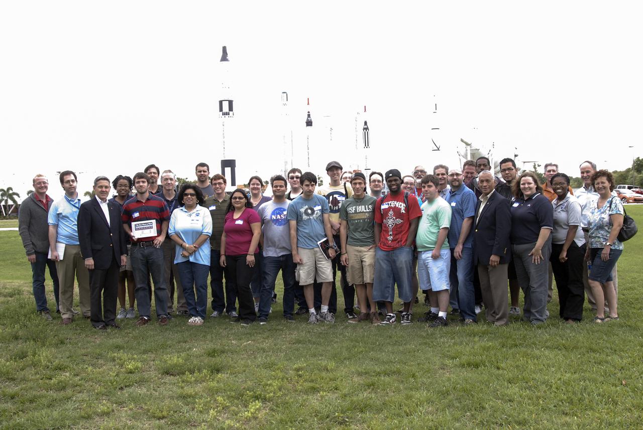 CAPE CANAVERAL, Fla. – Kennedy Space Center Director Bob Cabana, third from left, and NASA Administrator Charlie Bolden, fourth from right, gather with participants, subject matter experts and volunteers in front of the Rocket Garden at the Kennedy Space Center Visitor Complex in Florida during the 2013 International Space Apps Challenge. The group took a brief break before returning to The Astronaut Memorial Foundation’s Center for Space Education to continue working on their challenges.  During the worldwide two-day challenge, more than 9,000 people and 484 organizations came together in 83 cities across 44 countries, as well as online, to develop new ways of solving challenges that NASA faces. At Kennedy, four teams brainstormed ideas with subject matter experts and others and worked nearly 32 hours straight to present their concepts to a panel of three technical and non-technical judges. Challenges tackled at Kennedy were: Deployable Greenhouse, Kennedy Space Center 2040, Seven Minutes of Science, and Moonville – Lunar Industry Game. Photo credit: NASA_Charisse Nahser