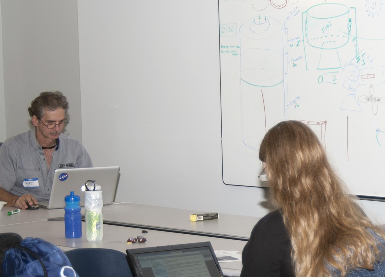 CAPE CANAVERAL, Fla. – Pat Starace, at left, from Orlando, and Kennedy Space Center engineer Jamie Szafran brainstorm ideas on deployable greenhouses during the 2013 International Space Apps Challenge, or ISAC, at The Astronaut Memorial Foundation’s Center for Space Education in Florida. During the worldwide two-day challenge, more than 9,000 people and 484 organizations came together in 83 cities across 44 countries, as well as online, to develop new ways of solving challenges that NASA faces. At Kennedy, four teams brainstormed ideas with subject matter experts and others and worked nearly 32 hours straight to present their concepts to a panel of three technical and non-technical judges. Challenges tackled at Kennedy were: Deployable Greenhouse, Kennedy Space Center 2040, Seven Minutes of Science, and Moonville – Lunar Industry Game. Photo credit: NASA_Charisse Nahser