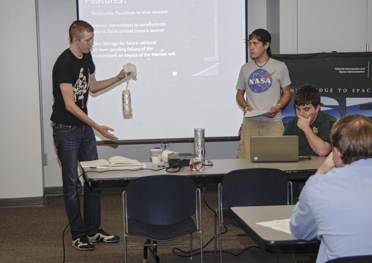 CAPE CANAVERAL, Fla. – Michael Strittmatter, at left, Joey Vars and Allan Pinkerton, all students at the University of South Florida St. Petersburg, present their ideas to a panel of technical and non-technical judges during the 2013 International Space Apps Challenge at The Astronaut Memorial Foundation’s Center for Space Education in Florida. During the worldwide two-day challenge, more than 9,000 people and 484 organizations came together in 83 cities across 44 countries, as well as online, to develop new ways of solving challenges that NASA faces. At Kennedy, four teams brainstormed ideas with subject matter experts and others and worked nearly 32 hours straight to present their concepts to a panel of three technical and non-technical judges. Challenges tackled at Kennedy were: Deployable Greenhouse, Kennedy Space Center 2040, Seven Minutes of Science, and Moonville – Lunar Industry Game. Photo credit: NASA_Charisse Nahser