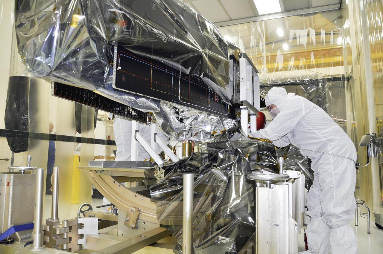 VANDENBERG AFB, Calif. – A technician removes protective Mylar wrapping from NASA's IRIS spacecraft in a clean room at Vandenberg where the spacecraft will be readied for launch aboard an Orbital Sciences Pegasus XL rocket. IRIS is short for Interface Region Imaging Spectrograph and the spacecraft's mission will improve our understanding of how heat and energy move through the deepest levels of the sun’s atmosphere, thereby increasing our ability to forecast space weather. Photo credit: VAFB_Randy Beaudoin