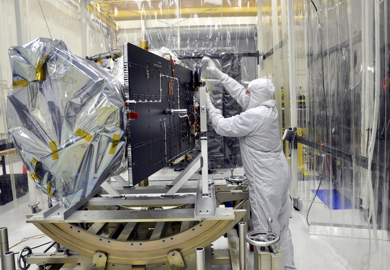 VANDENBERG AFB, Calif. – A technician removes protective Mylar wrapping from NASA's IRIS spacecraft in a clean room at Vandenberg where the spacecraft will be readied for launch aboard an Orbital Sciences Pegasus XL rocket. IRIS is short for Interface Region Imaging Spectrograph and the spacecraft's mission will improve our understanding of how heat and energy move through the deepest levels of the sun’s atmosphere, thereby increasing our ability to forecast space weather. Photo credit: VAFB_Randy Beaudoin