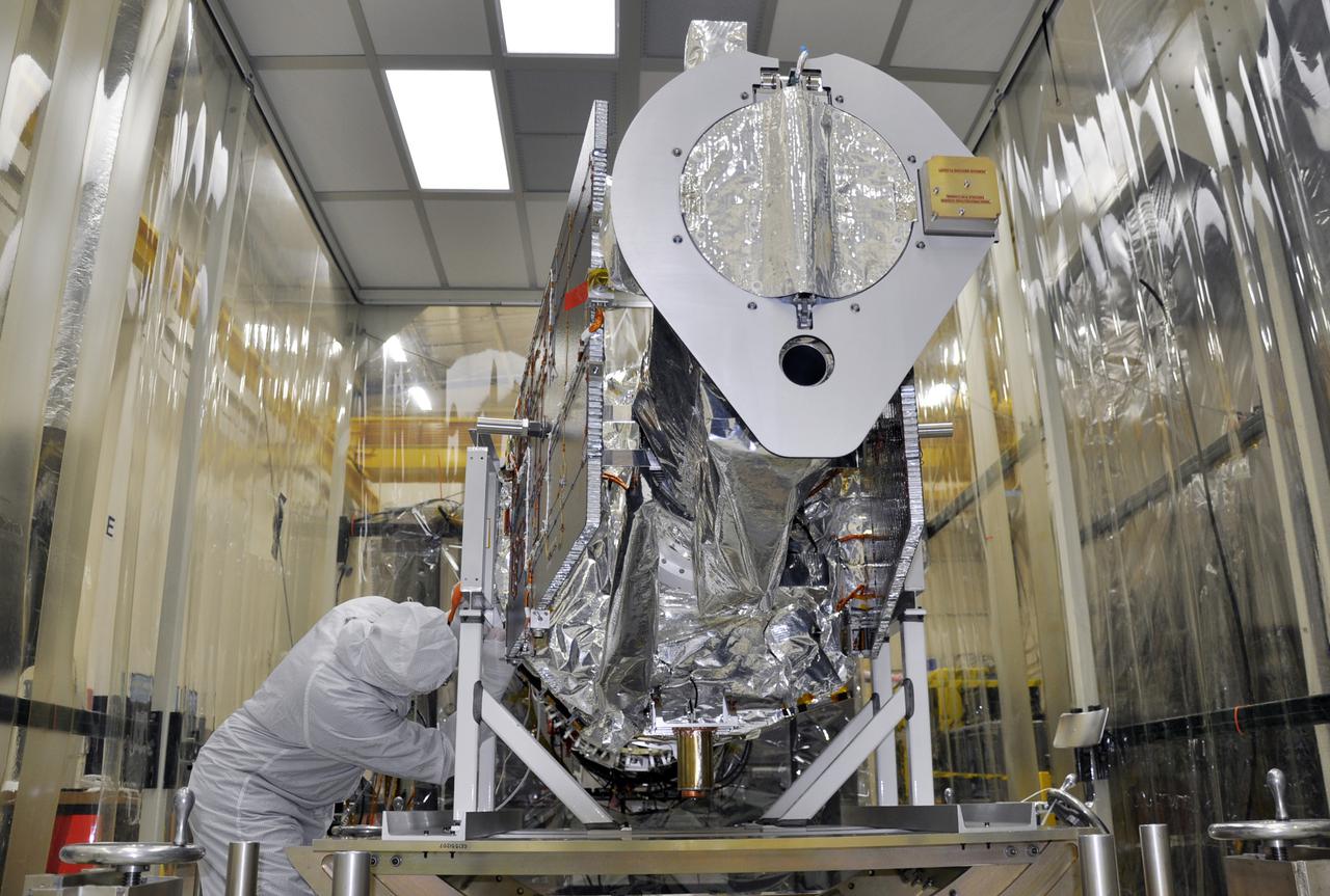VANDENBERG AFB, Calif. – A technician finishes removing protective Mylar wrapping from NASA's IRIS spacecraft in a clean room at Vandenberg where the spacecraft will be readied for launch aboard an Orbital Sciences Pegasus XL rocket. IRIS is short for Interface Region Imaging Spectrograph and the spacecraft's mission will improve our understanding of how heat and energy move through the deepest levels of the sun’s atmosphere, thereby increasing our ability to forecast space weather. Photo credit: VAFB_Randy Beaudoin
