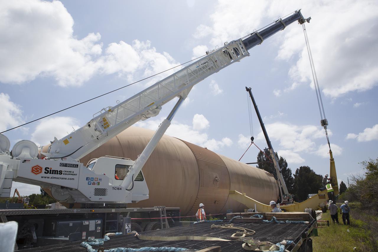 CAPE CANAVERAL, Fla. – Volunteers prepare an orange flight test article shuttle external fuel tank, or ET, for transport from NASA's Kennedy Space Center in Florida to the Wings of Dreams Aviation Museum located at Keystone Heights Airport in North Central Florida. Weighing in at 58,000 pounds unfueled and standing more than 15-stories tall, the ET was referred to as the 'backbone' of the space shuttle. Its job was to hold about 535,000 gallons of super-cold liquid hydrogen and liquid oxygen. It also absorbed the thrust loads produced at launch by the orbiter and the solid rocket boosters, or SRBs. Also joining the ET at Wings of Dreams is an ET transporter, the crew transport vehicle, crew hatch access vehicle, SRB aft skirt and SRB frustum.  Thousands of unique space shuttle era artifacts are being allocated to facilities across the country for their new missions to educate and inspire America's next generation of explorers. Photo credit: NASA_Dimitri Gerondidakis