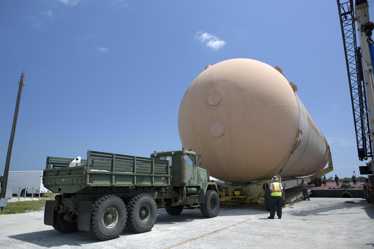 CAPE CANAVERAL, Fla. – An orange flight test article space shuttle external fuel tank, or ET, is loaded onto a barge for the first leg of its journey from NASA's Kennedy Space Center in Florida to the Wings of Dreams Aviation Museum located at Keystone Heights Airport in North Central Florida. Weighing in at 58,000 pounds unfueled and standing more than 15-stories tall, the ET was referred to as the 'backbone' of the space shuttle. Its job was to hold about 535,000 gallons of super-cold liquid hydrogen and liquid oxygen. It also absorbed the thrust loads produced at launch by the orbiter and the solid rocket boosters, or SRBs. Also joining the ET at Wings of Dreams is an ET transporter, the crew transport vehicle, crew hatch access vehicle, SRB aft skirt and SRB frustum.  Thousands of unique space shuttle era artifacts are being allocated to facilities across the country for their new missions to educate and inspire America's next generation of explorers. Photo credit: NASA_Dimitri Gerondidakis