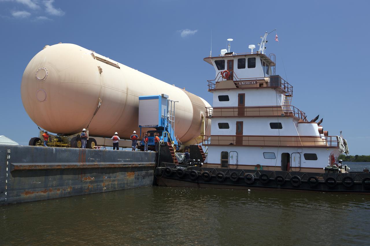 CAPE CANAVERAL, Fla. – An orange flight test article space shuttle external fuel tank, or ET, is loaded onto a barge for the first leg of its journey from NASA's Kennedy Space Center in Florida to the Wings of Dreams Aviation Museum located at Keystone Heights Airport in North Central Florida. Weighing in at 58,000 pounds unfueled and standing more than 15-stories tall, the ET was referred to as the 'backbone' of the space shuttle. Its job was to hold about 535,000 gallons of super-cold liquid hydrogen and liquid oxygen. It also absorbed the thrust loads produced at launch by the orbiter and the solid rocket boosters, or SRBs. Also joining the ET at Wings of Dreams is an ET transporter, the crew transport vehicle, crew hatch access vehicle, SRB aft skirt and SRB frustum.  Thousands of unique space shuttle era artifacts are being allocated to facilities across the country for their new missions to educate and inspire America's next generation of explorers. Photo credit: NASA_Dimitri Gerondidakis