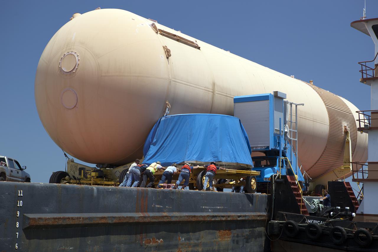CAPE CANAVERAL, Fla. – A space shuttle solid rocket booster, or SRB, aft skirt is loaded onto a barge for the first leg of its journey from NASA's Kennedy Space Center in Florida to the Wings of Dreams Aviation Museum located at Keystone Heights Airport in North Central Florida. Also joining the booster segment at Wings of Dreams is an orange flight test article external fuel tank, or ET, an ET transporter, the crew transport vehicle, crew hatch access vehicle and SRB frustum.  Thousands of unique space shuttle era artifacts are being allocated to facilities across the country for their new missions to educate and inspire America's next generation of explorers. Photo credit: NASA_Dimitri Gerondidakis