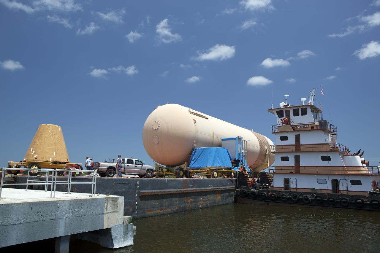 CAPE CANAVERAL, Fla. – A space shuttle solid rocket booster, or SRB, frustum is loaded onto a barge for the first leg of its journey from NASA's Kennedy Space Center in Florida to the Wings of Dreams Aviation Museum located at Keystone Heights Airport in North Central Florida. Also joining the booster segment at Wings of Dreams is an orange flight test article external fuel tank, or ET, an ET transporter, the crew transport vehicle, crew hatch access vehicle and SRB aft skirt.  Thousands of unique space shuttle era artifacts are being allocated to facilities across the country for their new missions to educate and inspire America's next generation of explorers. Photo credit: NASA_Dimitri Gerondidakis