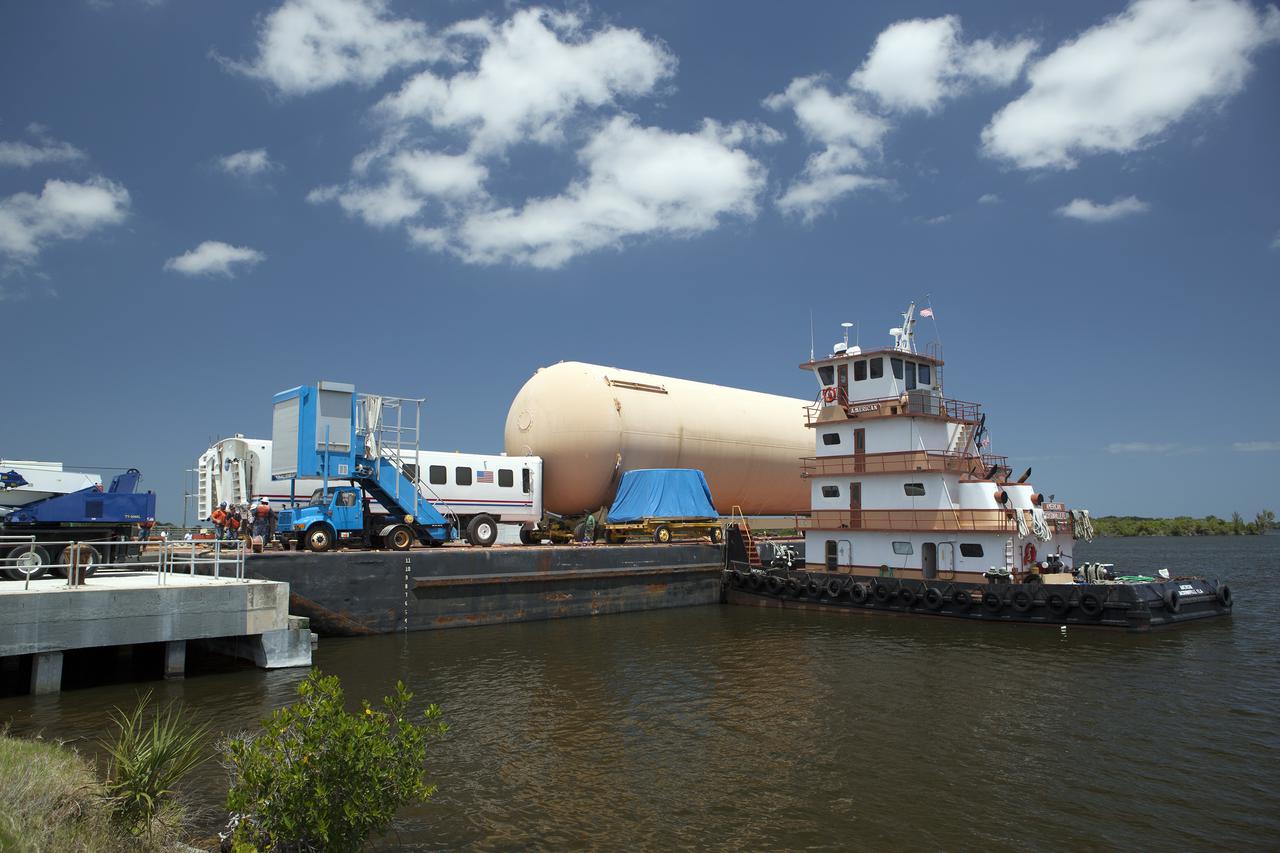 CAPE CANAVERAL, Fla. -- A space shuttle orange flight test article external fuel tank, or ET, an ET transporter, crew hatch access vehicle, crew transport vehicle, solid rocket booster, or SRB, aft skirt and SRB frustum are loaded onto a barge for the first leg of their journey from NASA's Kennedy Space Center in Florida to the Wings of Dreams Aviation Museum located at Keystone Heights Airport in North Central Florida.   Thousands of unique space shuttle era artifacts are being allocated to facilities across the country for their new missions to educate and inspire America's next generation of explorers. Photo credit: NASA_Dimitri Gerondidakis
