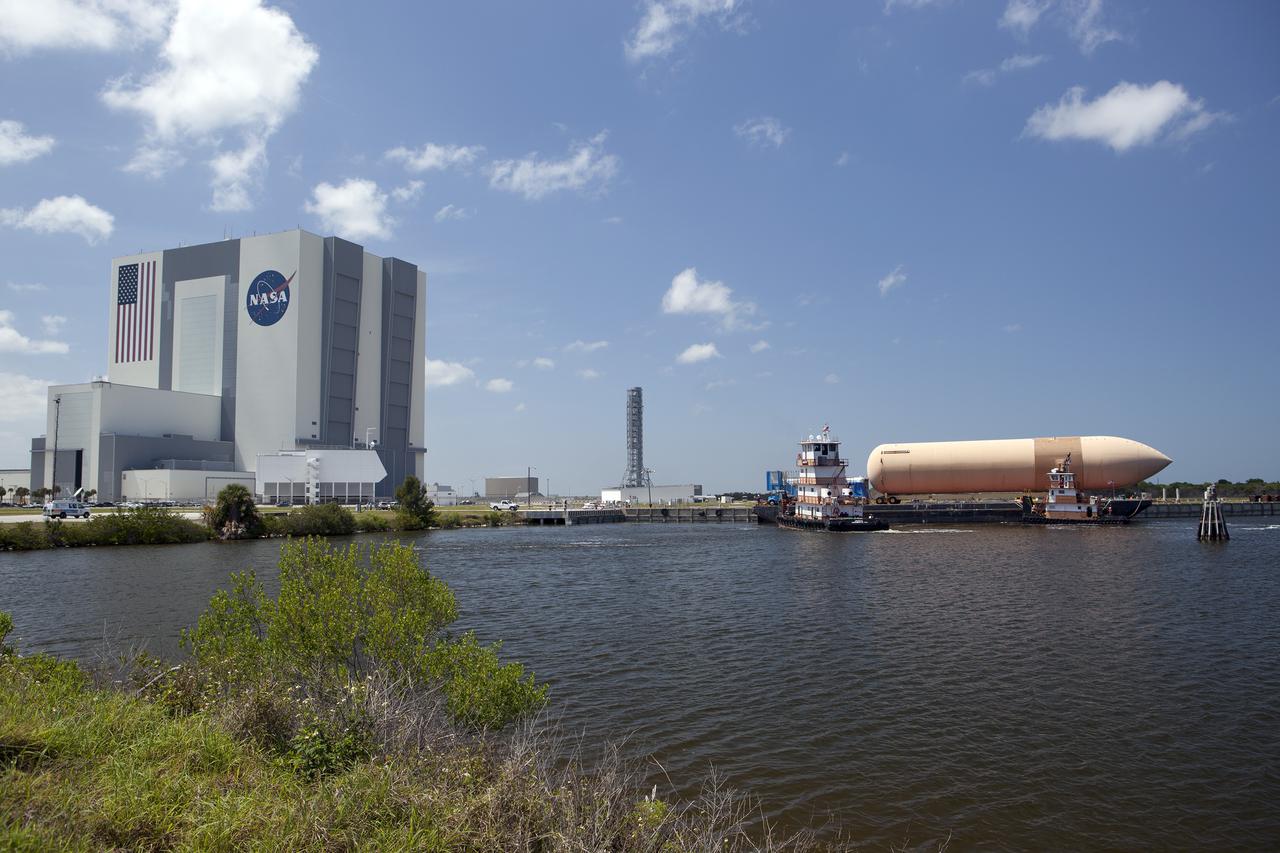 CAPE CANAVERAL, Fla. -- A space shuttle orange flight test article external fuel tank, or ET, an ET transporter, crew hatch access vehicle, crew transport vehicle, solid rocket booster, or SRB, aft skirt and SRB frustum are loaded onto a barge and beginning the first leg of their journey from NASA's Kennedy Space Center in Florida to the Wings of Dreams Aviation Museum located at Keystone Heights Airport in North Central Florida.   Thousands of unique space shuttle era artifacts are being allocated to facilities across the country for their new missions to educate and inspire America's next generation of explorers. Photo credit: NASA_Dimitri Gerondidakis