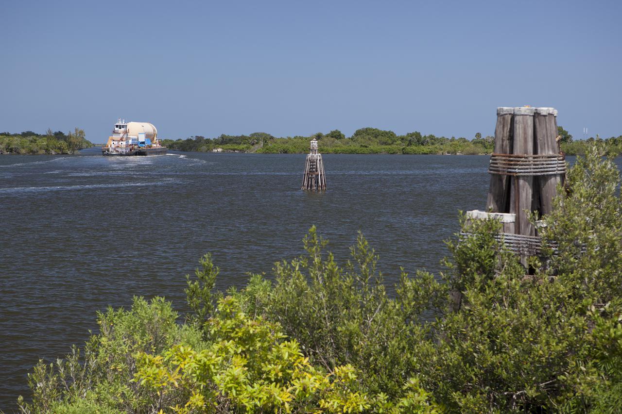 CAPE CANAVERAL, Fla. -- A space shuttle orange flight test article external fuel tank, or ET, an ET transporter, crew hatch access vehicle, crew transport vehicle, solid rocket booster, or SRB, aft skirt and SRB frustum are loaded onto a barge and beginning the first leg of their journey down the Banana River from NASA's Kennedy Space Center in Florida to the Wings of Dreams Aviation Museum located at Keystone Heights Airport in North Central Florida.   Thousands of unique space shuttle era artifacts are being allocated to facilities across the country for their new missions to educate and inspire America's next generation of explorers. Photo credit: NASA_Dimitri Gerondidakis