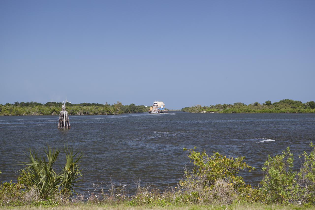 CAPE CANAVERAL, Fla. – A space shuttle orange flight test article external fuel tank, or ET, an ET transporter, crew hatch access vehicle, crew transport vehicle, solid rocket booster, or SRB, aft skirt and SRB frustum are loaded onto a barge and beginning the first leg of their journey down the Banana River from NASA's Kennedy Space Center in Florida to the Wings of Dreams Aviation Museum located at Keystone Heights Airport in North Central Florida.   Thousands of unique space shuttle era artifacts are being allocated to facilities across the country for their new missions to educate and inspire America's next generation of explorers. Photo credit: NASA_Dimitri Gerondidakis