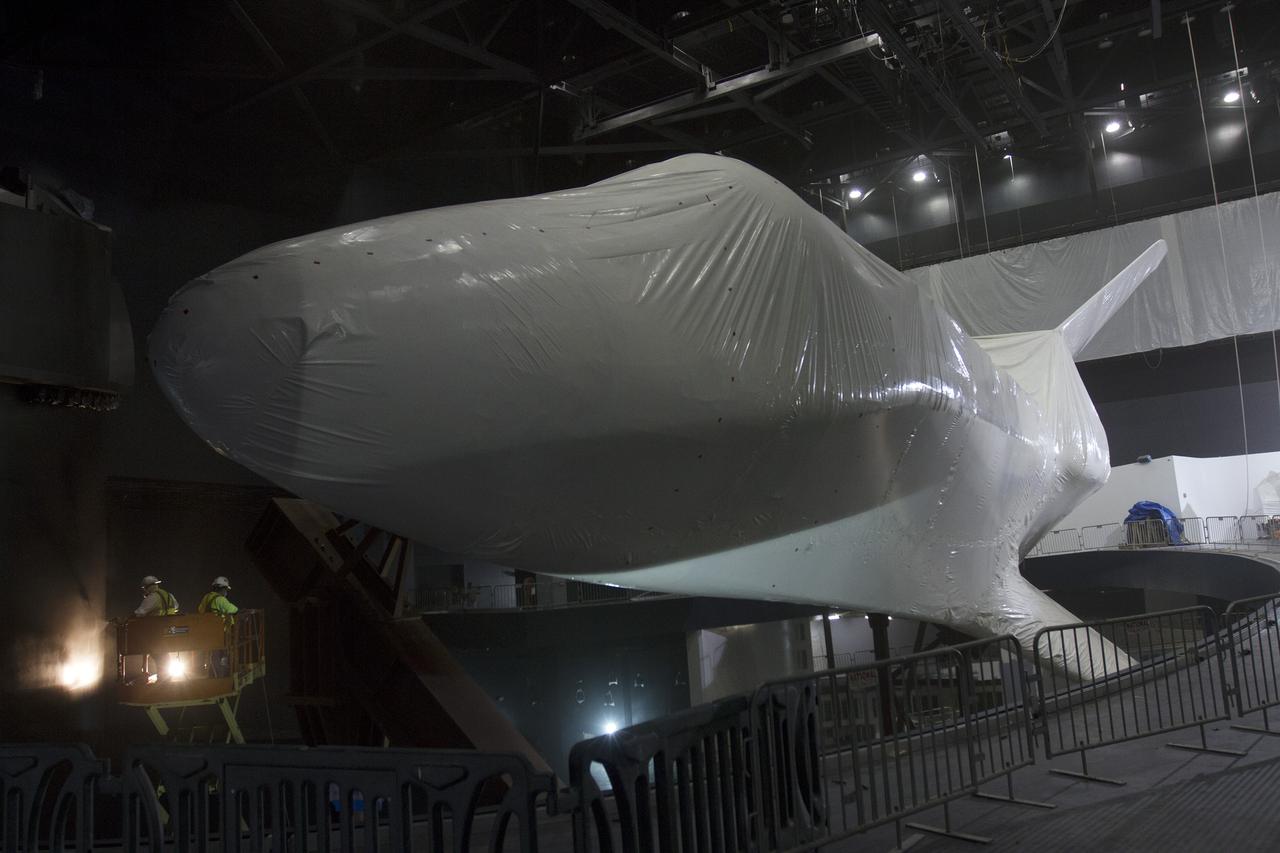 CAPE CANAVERAL, Fla. -- At the Kennedy Space Center Visitor Complex in Florida, construction crews prepare to remove 16,000 square feet of plastic shrink-wrap from the space shuttle Atlantis. The spacecraft was enclosed in the plastic shrink-wrap since November of last year to protect the artifact from dust and debris during construction of the 90,000-square-foot facility. Last November, the space shuttle Atlantis made its historic final journey to its new home, traveling 10 miles from the Kennedy Space Center's Vehicle Assembly Building to the spaceport's visitor complex. The new $100 million 'Space Shuttle Atlantis' facility will include interactive exhibits that tell the story of the 30-year Space Shuttle Program and highlights the future of space exploration. The 'Space Shuttle Atlantis' exhibit scheduled to open June 29, 2013.Photo credit: NASA_Cory Huston