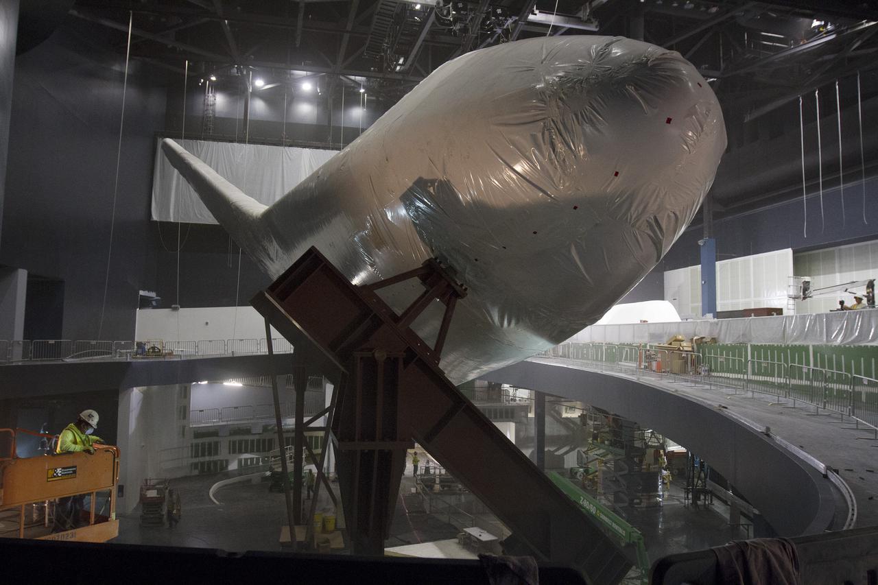 CAPE CANAVERAL, Fla. -- At the Kennedy Space Center Visitor Complex in Florida, construction crews prepare to remove 16,000 square feet of plastic shrink-wrap from the space shuttle Atlantis. The spacecraft was enclosed in the plastic shrink-wrap since November of last year to protect the artifact from dust and debris during construction of the 90,000-square-foot facility. Last November, the space shuttle Atlantis made its historic final journey to its new home, traveling 10 miles from the Kennedy Space Center's Vehicle Assembly Building to the spaceport's visitor complex. The new $100 million 'Space Shuttle Atlantis' facility will include interactive exhibits that tell the story of the 30-year Space Shuttle Program and highlights the future of space exploration. The 'Space Shuttle Atlantis' exhibit scheduled to open June 29, 2013.Photo credit: NASA_Cory Huston