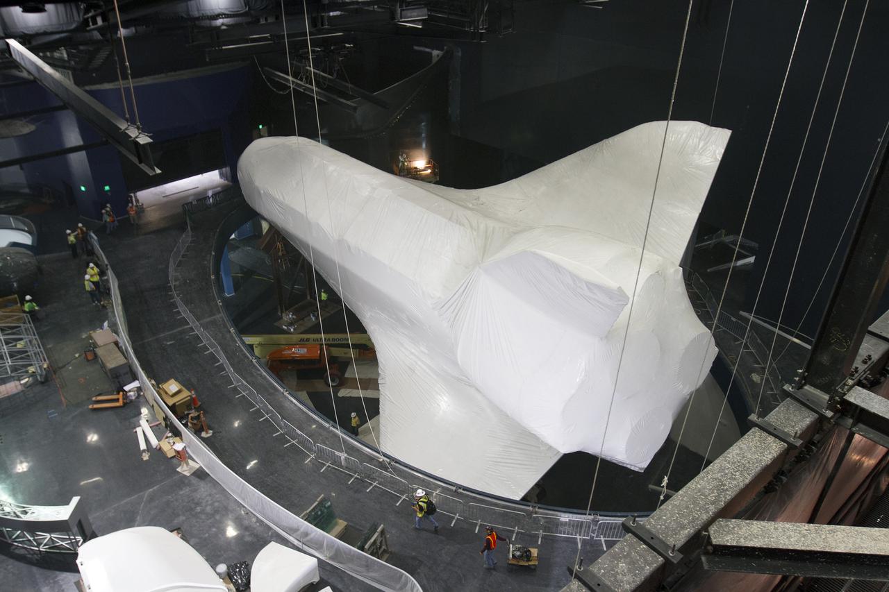 CAPE CANAVERAL, Fla. -- At the Kennedy Space Center Visitor Complex in Florida, construction crews prepare to remove 16,000 square feet of plastic shrink-wrap from the space shuttle Atlantis. The spacecraft was enclosed in the plastic shrink-wrap since November of last year to protect the artifact from dust and debris during construction of the 90,000-square-foot facility. Last November, the space shuttle Atlantis made its historic final journey to its new home, traveling 10 miles from the Kennedy Space Center's Vehicle Assembly Building to the spaceport's visitor complex. The new $100 million 'Space Shuttle Atlantis' facility will include interactive exhibits that tell the story of the 30-year Space Shuttle Program and highlights the future of space exploration. The 'Space Shuttle Atlantis' exhibit scheduled to open June 29, 2013.Photo credit: NASA_Cory Huston
