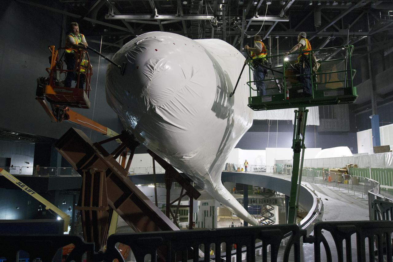 CAPE CANAVERAL, Fla. -- At the Kennedy Space Center Visitor Complex in Florida, construction crews begin removing 16,000 square feet of plastic shrink-wrap from the space shuttle Atlantis. The spacecraft was enclosed in the plastic shrink-wrap since November of last year to protect the artifact from dust and debris during construction of the 90,000-square-foot facility. Last November, the space shuttle Atlantis made its historic final journey to its new home, traveling 10 miles from the Kennedy Space Center's Vehicle Assembly Building to the spaceport's visitor complex. The new $100 million 'Space Shuttle Atlantis' facility will include interactive exhibits that tell the story of the 30-year Space Shuttle Program and highlights the future of space exploration. The 'Space Shuttle Atlantis' exhibit scheduled to open June 29, 2013.Photo credit: NASA_Cory Huston
