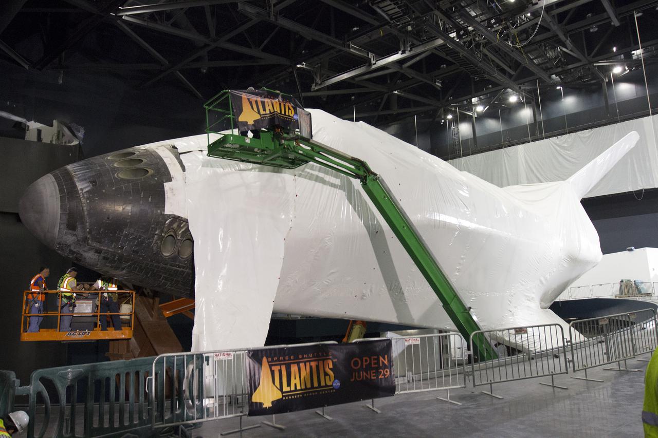 CAPE CANAVERAL, Fla. -- At the Kennedy Space Center Visitor Complex in Florida, the nose cap and part of the forward reaction control system is uncovered as construction crews begin removing 16,000 square feet of plastic shrink-wrap from the space shuttle Atlantis. The spacecraft was enclosed in the plastic shrink-wrap since November of last year to protect the artifact from dust and debris during construction of the 90,000-square-foot facility. Last November, the space shuttle Atlantis made its historic final journey to its new home, traveling 10 miles from the Kennedy Space Center's Vehicle Assembly Building to the spaceport's visitor complex. The new $100 million 'Space Shuttle Atlantis' facility will include interactive exhibits that tell the story of the 30-year Space Shuttle Program and highlights the future of space exploration. The 'Space Shuttle Atlantis' exhibit scheduled to open June 29, 2013.Photo credit: NASA_Cory Huston