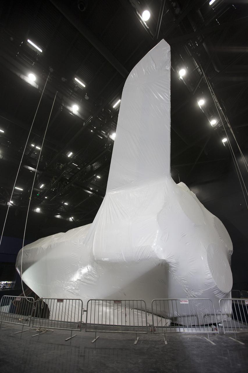 CAPE CANAVERAL, Fla. -- At the Kennedy Space Center Visitor Complex in Florida, construction crews prepare to remove 16,000 square feet of plastic shrink-wrap from the space shuttle Atlantis. The spacecraft was enclosed in the plastic shrink-wrap since November of last year to protect the artifact from dust and debris during construction of the 90,000-square-foot facility. Last November, the space shuttle Atlantis made its historic final journey to its new home, traveling 10 miles from the Kennedy Space Center's Vehicle Assembly Building to the spaceport's visitor complex. The new $100 million 'Space Shuttle Atlantis' facility will include interactive exhibits that tell the story of the 30-year Space Shuttle Program and highlights the future of space exploration. The 'Space Shuttle Atlantis' exhibit scheduled to open June 29, 2013.Photo credit: NASA_Kim Shiflett