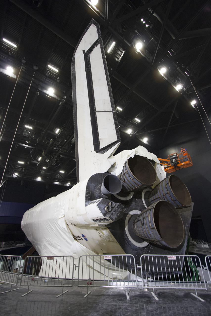 CAPE CANAVERAL, Fla. -- At the Kennedy Space Center Visitor Complex in Florida, construction crews remove 16,000 square feet of plastic shrink-wrap from the space shuttle Atlantis. The spacecraft was enclosed in the plastic shrink-wrap since November of last year to protect the artifact from dust and debris during construction of the 90,000-square-foot facility. Last November, the space shuttle Atlantis made its historic final journey to its new home, traveling 10 miles from the Kennedy Space Center's Vehicle Assembly Building to the spaceport's visitor complex. The new $100 million 'Space Shuttle Atlantis' facility will include interactive exhibits that tell the story of the 30-year Space Shuttle Program and highlights the future of space exploration. The 'Space Shuttle Atlantis' exhibit scheduled to open June 29, 2013.Photo credit: NASA_ Cory Huston