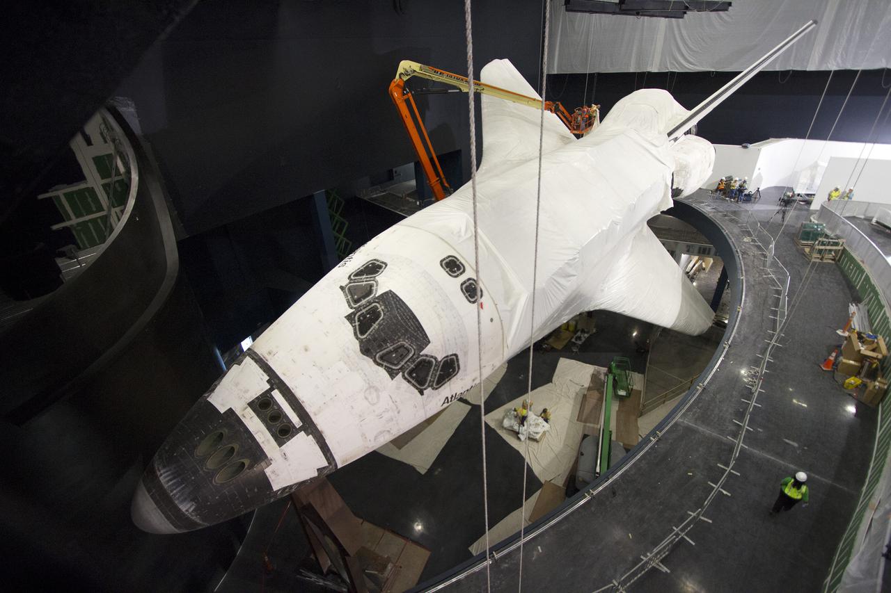 CAPE CANAVERAL, Fla. -- At the Kennedy Space Center Visitor Complex in Florida, construction crews remove 16,000 square feet of plastic shrink-wrap from the space shuttle Atlantis. The spacecraft was enclosed in the plastic shrink-wrap since November of last year to protect the artifact from dust and debris during construction of the 90,000-square-foot facility. Last November, the space shuttle Atlantis made its historic final journey to its new home, traveling 10 miles from the Kennedy Space Center's Vehicle Assembly Building to the spaceport's visitor complex. The new $100 million 'Space Shuttle Atlantis' facility will include interactive exhibits that tell the story of the 30-year Space Shuttle Program and highlights the future of space exploration. The 'Space Shuttle Atlantis' exhibit scheduled to open June 29, 2013.Photo credit: NASA_ Cory Huston