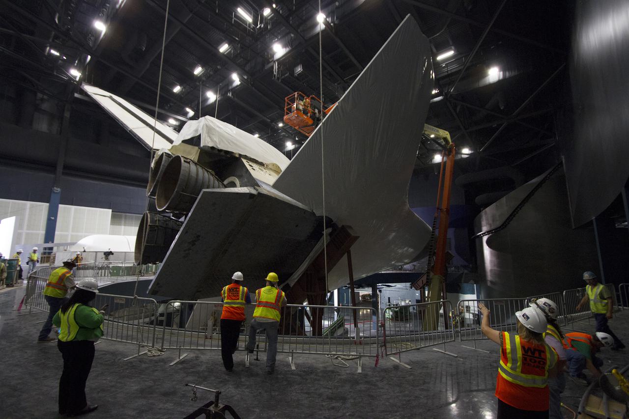 CAPE CANAVERAL, Fla. -- At the Kennedy Space Center Visitor Complex in Florida, construction crews remove 16,000 square feet of plastic shrink-wrap from the space shuttle Atlantis. The spacecraft was enclosed in the plastic shrink-wrap since November of last year to protect the artifact from dust and debris during construction of the 90,000-square-foot facility. Last November, the space shuttle Atlantis made its historic final journey to its new home, traveling 10 miles from the Kennedy Space Center's Vehicle Assembly Building to the spaceport's visitor complex. The new $100 million 'Space Shuttle Atlantis' facility will include interactive exhibits that tell the story of the 30-year Space Shuttle Program and highlights the future of space exploration. The 'Space Shuttle Atlantis' exhibit scheduled to open June 29, 2013.Photo credit: NASA_ Cory Huston