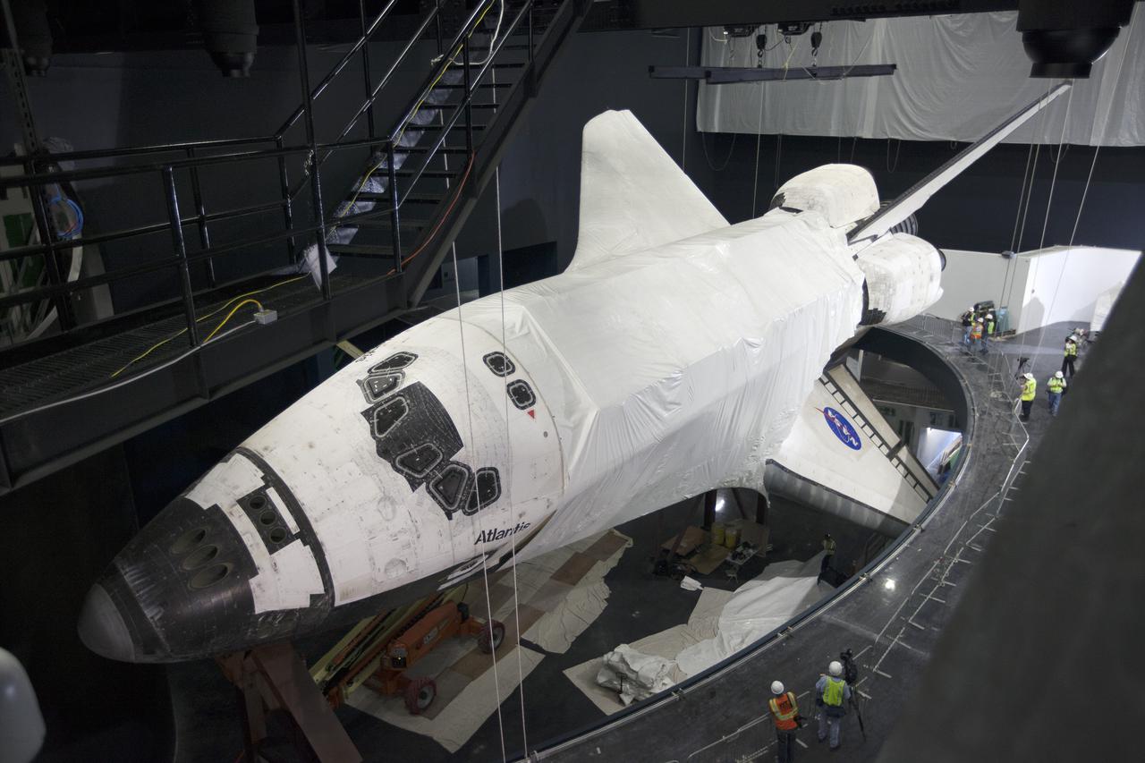CAPE CANAVERAL, Fla. -- At the Kennedy Space Center Visitor Complex in Florida, construction crews remove 16,000 square feet of plastic shrink-wrap from the space shuttle Atlantis. The spacecraft was enclosed in the plastic shrink-wrap since November of last year to protect the artifact from dust and debris during construction of the 90,000-square-foot facility.   Last November, the space shuttle Atlantis made its historic final journey to its new home, traveling 10 miles from the Kennedy Space Center's Vehicle Assembly Building to the spaceport's visitor complex. The new $100 million 'Space Shuttle Atlantis' facility will include interactive exhibits that tell the story of the 30-year Space Shuttle Program and highlights the future of space exploration. The 'Space Shuttle Atlantis' exhibit scheduled to open June 29, 2013.Photo credit: NASA_Kim Shiflett