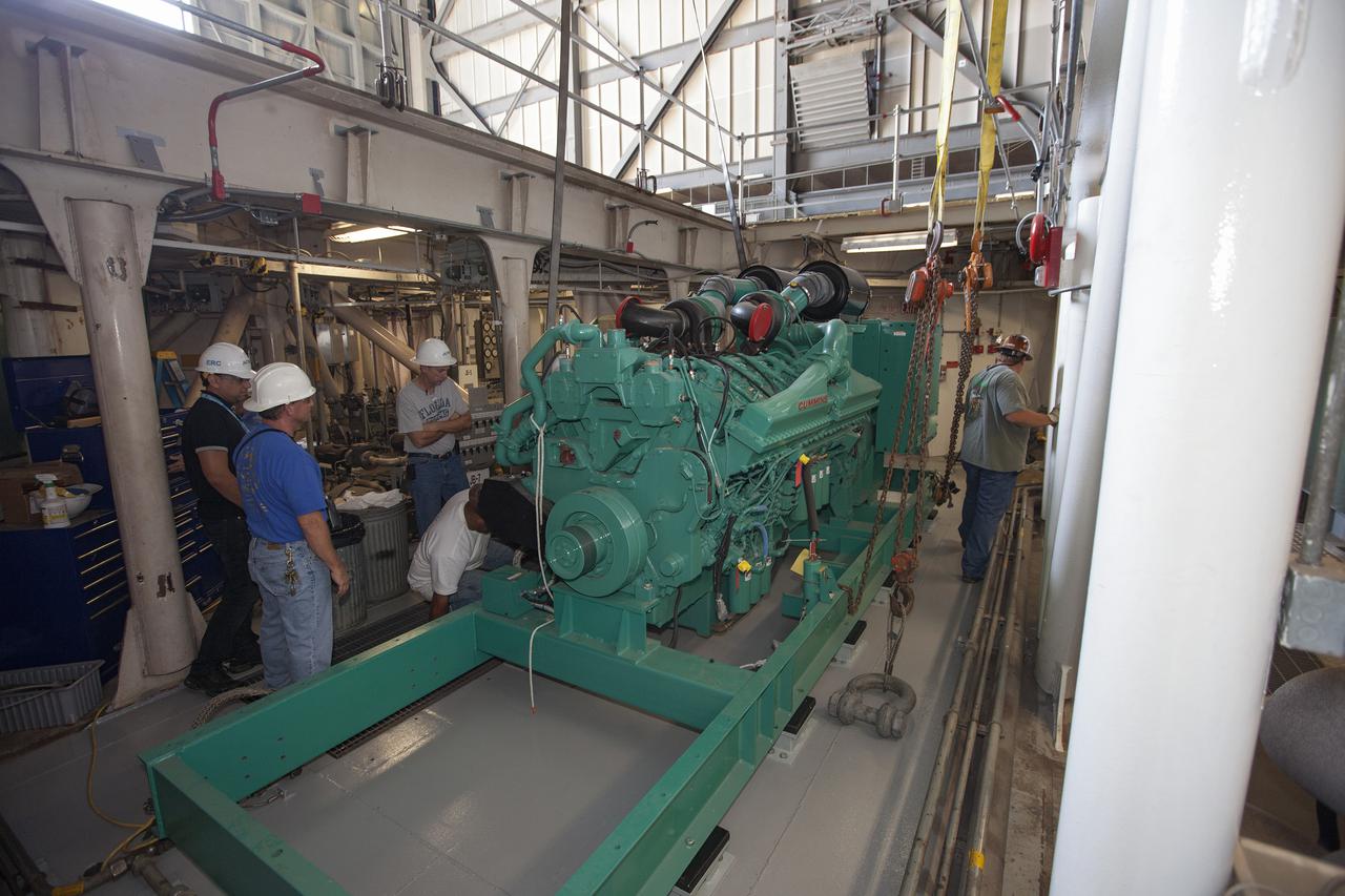 CAPE CANAVERAL, Fla. – Inside the Vehicle Assembly Building at NASA’s Kennedy Space Center in Florida, technicians begin the work to secure a new Cummins engine and generator inside crawler-transporter 1 CT-1. The Apollo era diesel engines were removed so that the new engine can be installed.      Work continues in high bay 3 to upgrade CT-1 as part of its general maintenance and could be available to carry commercial launch vehicles to the launch pad. The crawler-transporters were used to carry the mobile launcher platform and space shuttle to Launch Complex 39 for space shuttle launches for 30 years.  Photo credit: NASA_Kim Shiflett