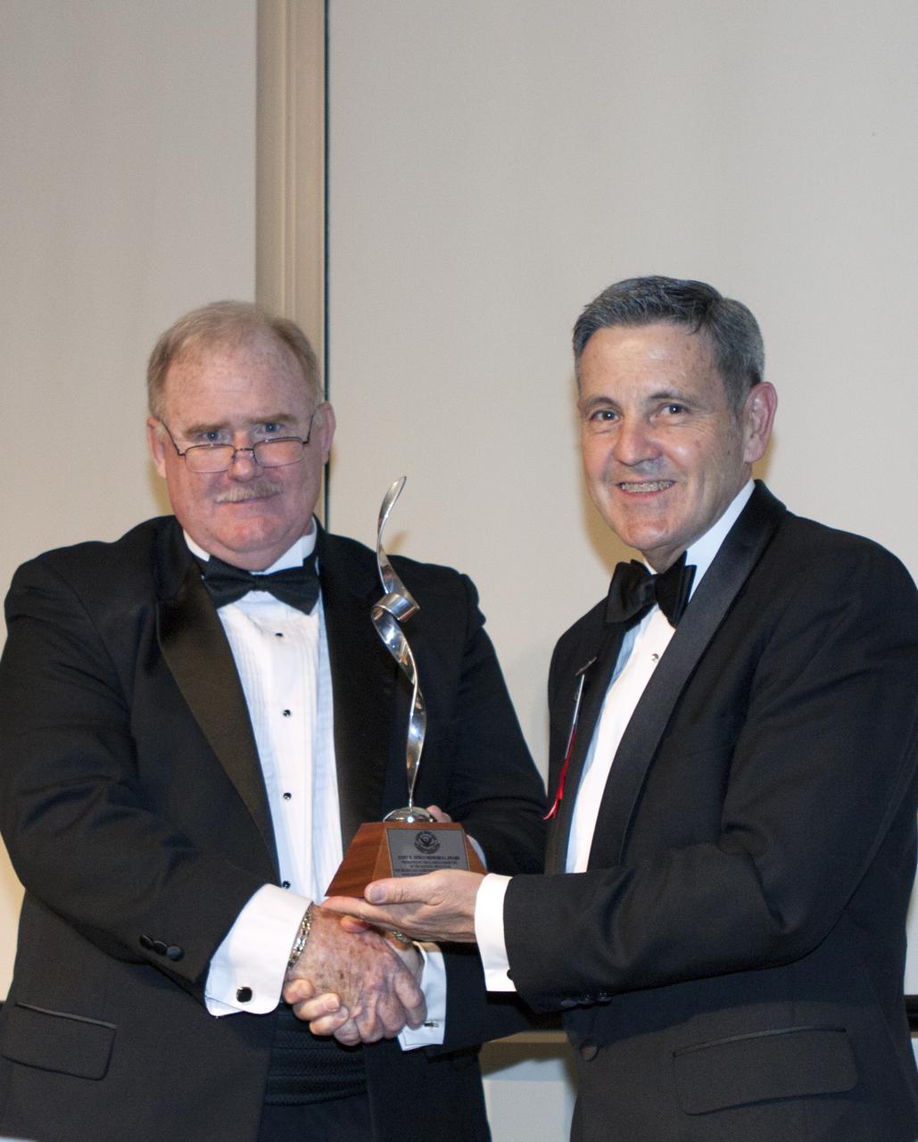 CAPE CANAVERAL, Fla. – At NASA’s Kennedy Space Center Visitor Complex in Florida, National Space Club Florida Committee Chairman Jim McCarthy, left, presents the Dr. Kurt H. Debus Award to Kennedy's director, Bob Cabana. A former U.S. Marine Corps aviator and NASA astronaut, Cabana was honored at the gala Debus Award Dinner. Named for the spaceport’s first director, the Debus Award was created to recognize significant achievements and contributions made in Florida to American aerospace efforts. The Debus Award was created by the space club's Florida committee to recognize significant achievements and contributions made in Florida to American aerospace efforts. Photo credit: NASA_Jim Grossmann