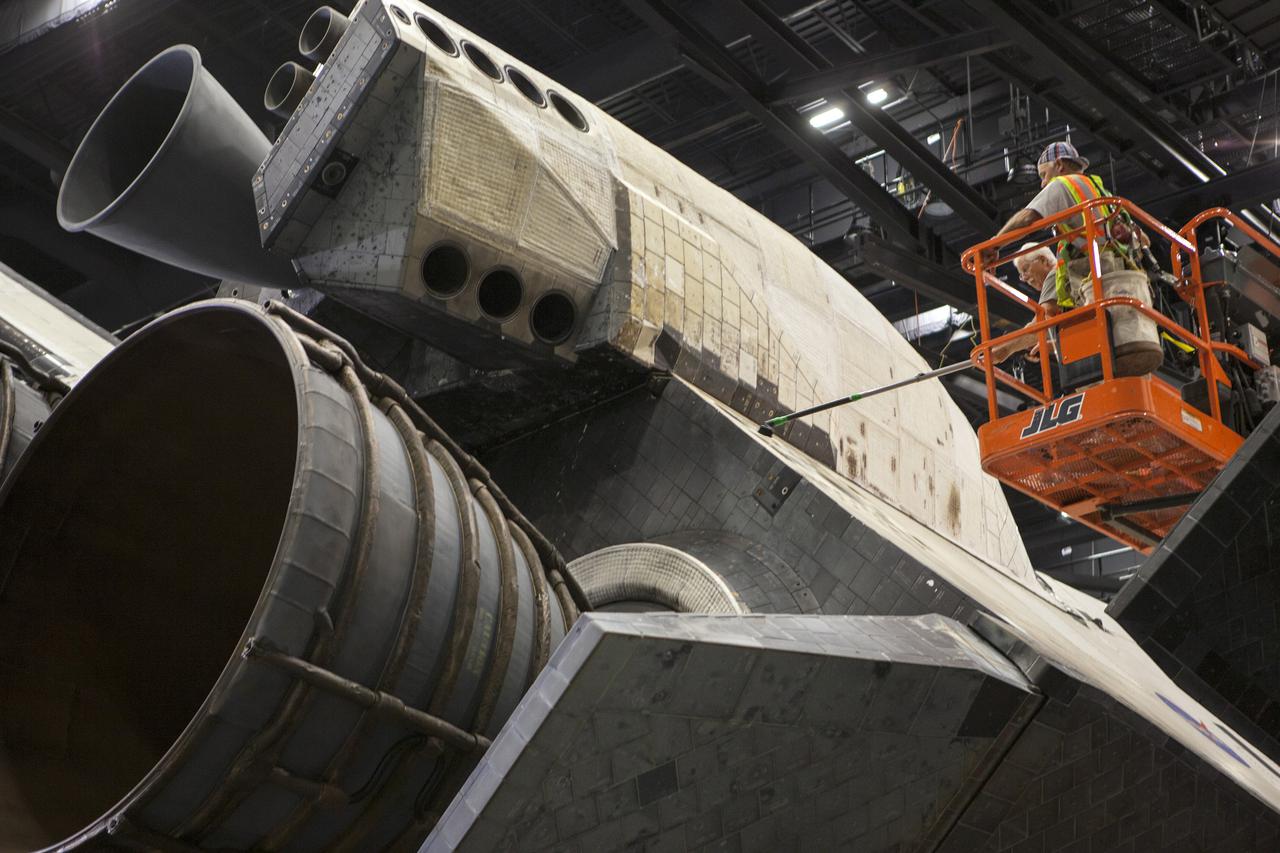 CAPE CANAVERAL, Fla. – Construction crews clean space shuttle Atlantis following the removal of 16,000 square feet of plastic shrink-wrap that enclosed the spacecraft since November of last year to protect the artifact from dust and debris during construction of the 90,000-square-foot facility. The new $100 million 'Space Shuttle Atlantis' facility will include interactive exhibits that tell the story of the 30-year Space Shuttle Program and highlights the future of space exploration. The 'Space Shuttle Atlantis' exhibit scheduled to open June 29, 2013. Photo credit: NASA_ Dmitri Gerondidakis