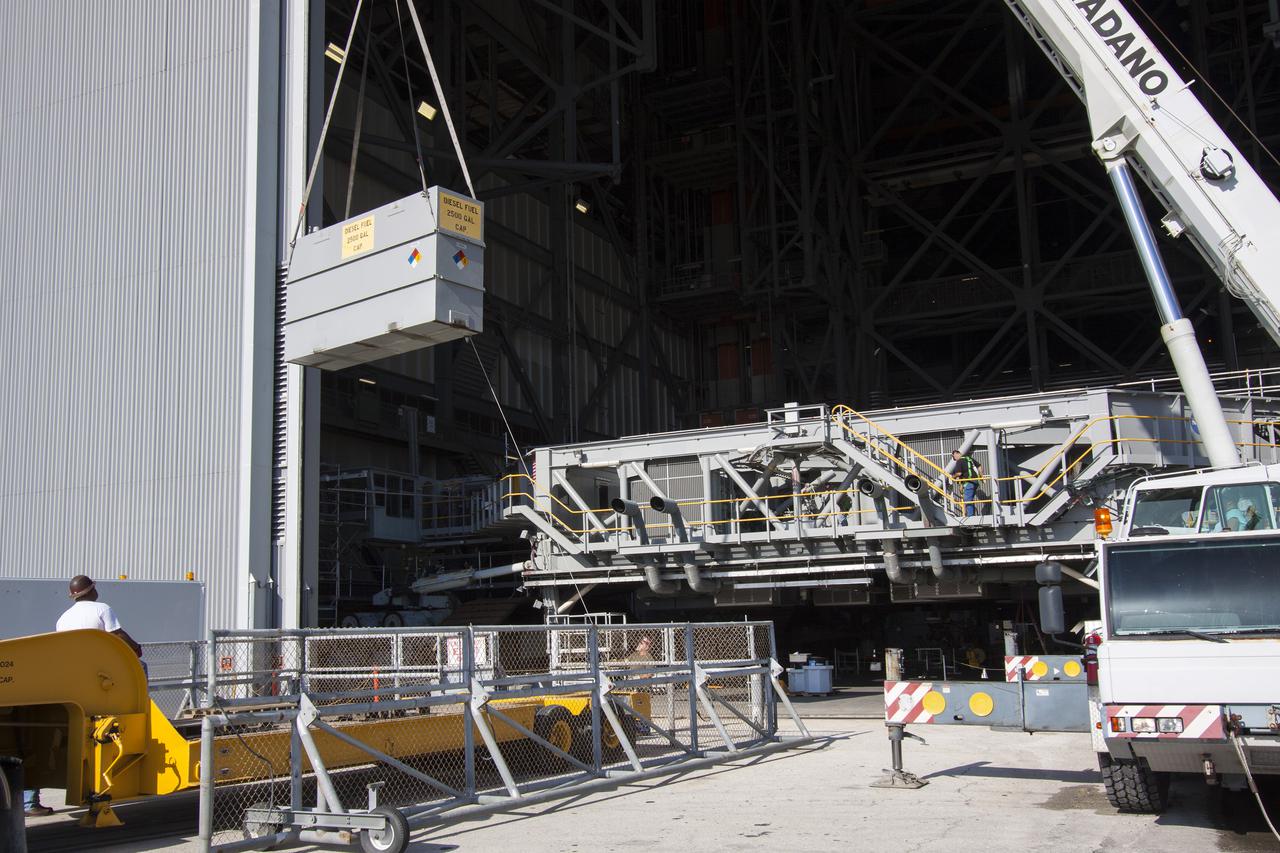 CAPE CANAVERAL, Fla. – Inside the Vehicle Assembly Building at NASA’s Kennedy Space Center in Florida, a large crane is used to lift a fuel tank away from crawler-transporter 1 CT-1 in high bay 3. The fuel tank will be transported to the Wiltech facility at Kennedy for cleaning and inspection.  Work continues in high bay 3 to upgrade CT-1 as part of its general maintenance. CT-1 could be available to carry commercial launch vehicles to the launch pad. The crawler-transporters were used to carry the mobile launcher platform and space shuttle to Launch Complex 39 for space shuttle launches for 30 years.  Photo credit: NASA_Jim Grossman