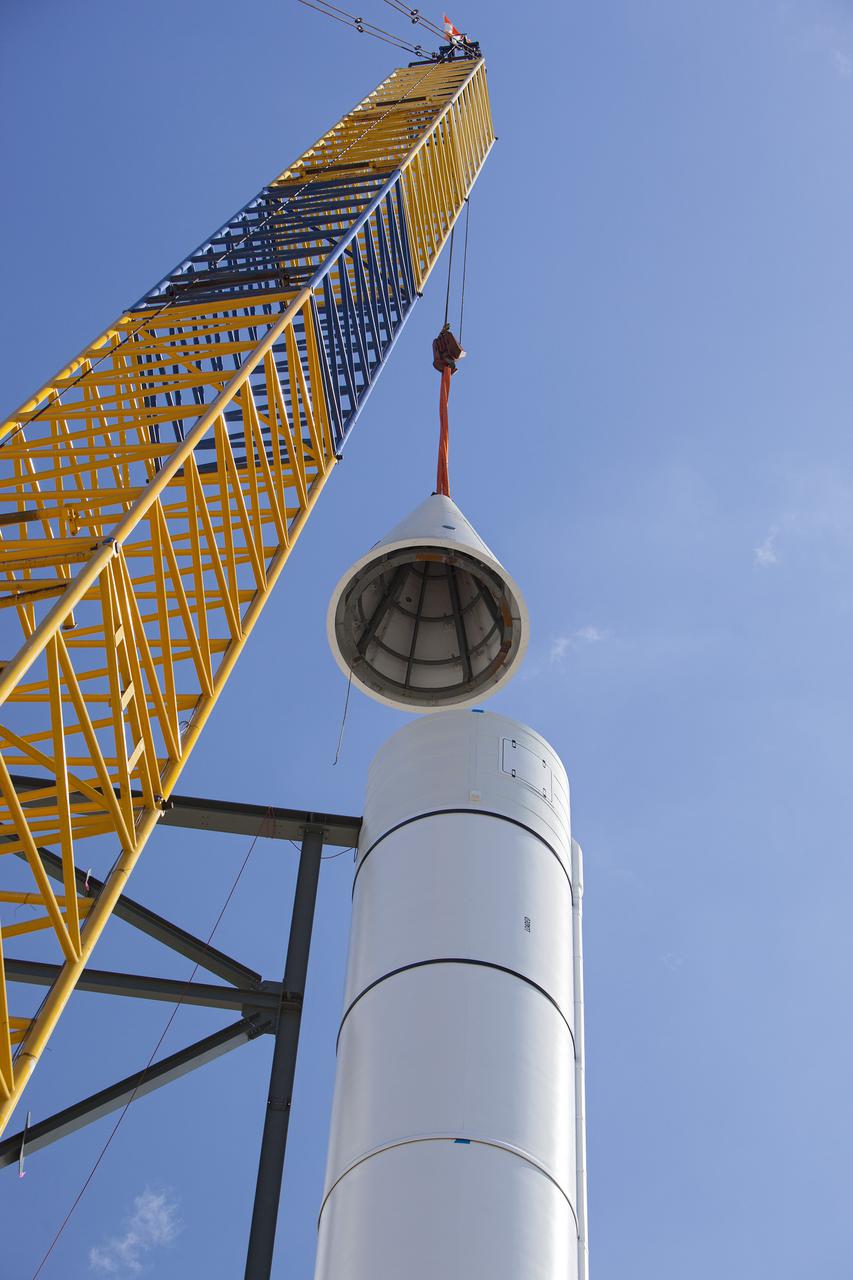 CAPE CANAVERAL, Fla. – A crane lifts the nosecone part of a solid rocket booster replica into place at the Kennedy Space Center Visitor Complex where the Space Shuttle Atlantis exhibit and attraction is under construction. Photo credit: NASA_Dmitri Gerondidakis