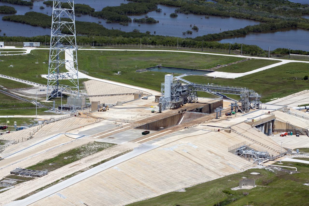 CAPE CANAVERAL, Fla. – An aerial view shows construction progress at Launch Pad 39B at NASA’s Kennedy Space Center in Florida. A new elevator has been constructed on the surface of the pad and the crawlerway leading up to the surface is being repaired. To the left is one of three tall lightning towers.  Upgrades are underway at Pad B and other facilities in the Launch Complex 39 area. The Ground Systems Development and Operations, or GSDO, Program office at Kennedy is leading the center’s transformation from a historically government-only launch complex to a spaceport that can safely handle a variety of rockets and spacecraft, including NASA’s Space Launch System. For more information about GSDO, visit: http:__go.nasa.gov_groundsystems.  Photo credit: NASA_Kim Shiflett