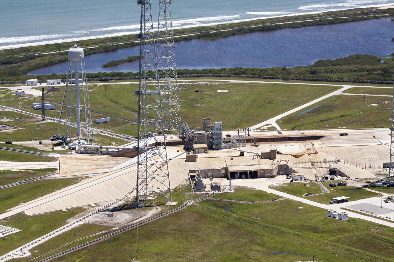 CAPE CANAVERAL, Fla. – An aerial view shows construction progress at Launch Pad 39B at NASA’s Kennedy Space Center in Florida. A new elevator has been constructed on the surface of the pad and the crawlerway leading up to the surface is being repaired. Repairs also are being made to the crawler track panels and catacomb roof below on either side of the flame trench. Also in view are the water tower and two of the three tall lightning towers that surround the pad.  Upgrades are underway at Pad B and other facilities in the Launch Complex 39 area. The Ground Systems Development and Operations, or GSDO, Program office at Kennedy is leading the center’s transformation from a historically government-only launch complex to a spaceport that can safely handle a variety of rockets and spacecraft, including NASA’s Space Launch System. For more information about GSDO, visit: http:__go.nasa.gov_groundsystems.  Photo credit: NASA_Kim Shiflett