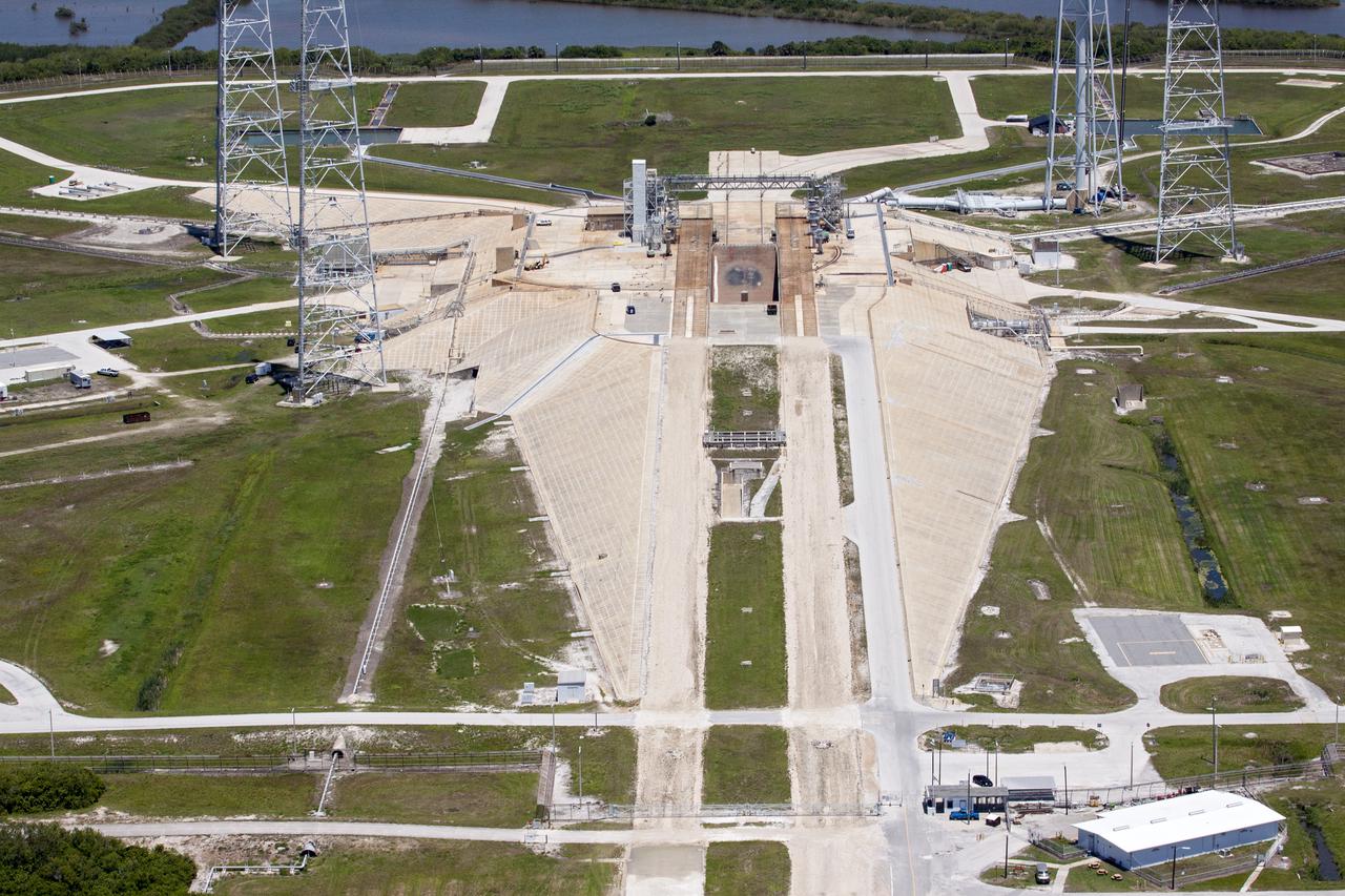 CAPE CANAVERAL, Fla. – An aerial view shows construction progress at Launch Pad 39B at NASA’s Kennedy Space Center in Florida. A new elevator has been constructed on the surface of the pad and the crawlerway leading up to the surface is being repaired. Repairs also are being made to the crawler track panels and catacomb roof below on either side of the flame trench. Also in view are portions of the water tower and the three tall lightning towers that surround the pad.  Upgrades are underway at Pad B and other facilities in the Launch Complex 39 area. The Ground Systems Development and Operations, or GSDO, Program office at Kennedy is leading the center’s transformation from a historically government-only launch complex to a spaceport that can safely handle a variety of rockets and spacecraft, including NASA’s Space Launch System. For more information about GSDO, visit: http:__go.nasa.gov_groundsystems.  Photo credit: NASA_Kim Shiflett