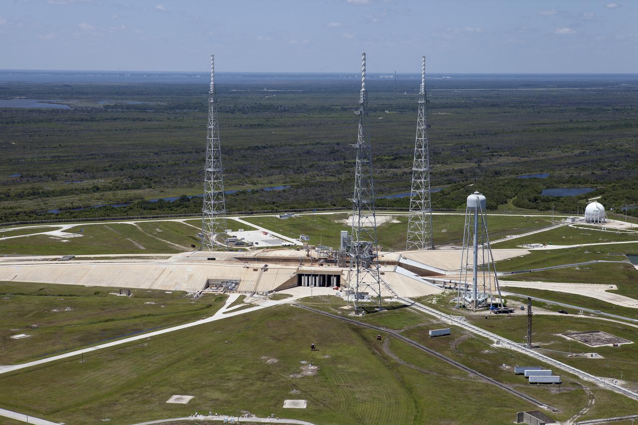 CAPE CANAVERAL, Fla. – An aerial view shows construction progress at Launch Pad 39B at NASA’s Kennedy Space Center in Florida. A new elevator has been constructed on the surface of the pad and the crawlerway leading up to the surface is being repaired. Repairs also are being made to the crawler track panels and catacomb roof below on either side of the flame trench. Also in view are the water tower and the three tall lightning towers that surround the pad.  Upgrades are underway at Pad B and other facilities in the Launch Complex 39 area. The Ground Systems Development and Operations, or GSDO, Program office at Kennedy is leading the center’s transformation from a historically government-only launch complex to a spaceport that can safely handle a variety of rockets and spacecraft, including NASA’s Space Launch System. For more information about GSDO, visit: http:__go.nasa.gov_groundsystems.  Photo credit: NASA_Kim Shiflett