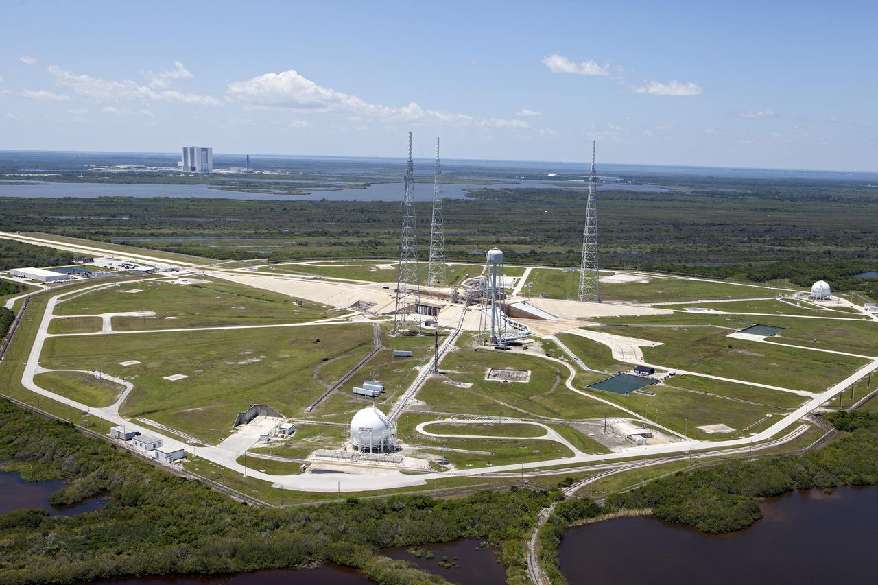 CAPE CANAVERAL, Fla. – An aerial view shows Launch Pad 39B at NASA’s Kennedy Space Center in Florida. A new elevator has been constructed on the surface of the pad and the crawlerway leading up to the surface is being repaired. Repairs also are being made to the crawler track panels and catacomb roof below on either side of the flame trench. Also in view are the water tower and the three tall lightning towers that surround the pad. To the left, in the background is the Vehicle Assembly Building.  Upgrades are underway at Pad B and other facilities in the Launch Complex 39 area. The Ground Systems Development and Operations, or GSDO, Program office at Kennedy is leading the center’s transformation from a historically government-only launch complex to a spaceport that can safely handle a variety of rockets and spacecraft, including NASA’s Space Launch System. For more information about GSDO, visit: http:__go.nasa.gov_groundsystems.  Photo credit: NASA_Kim Shiflett