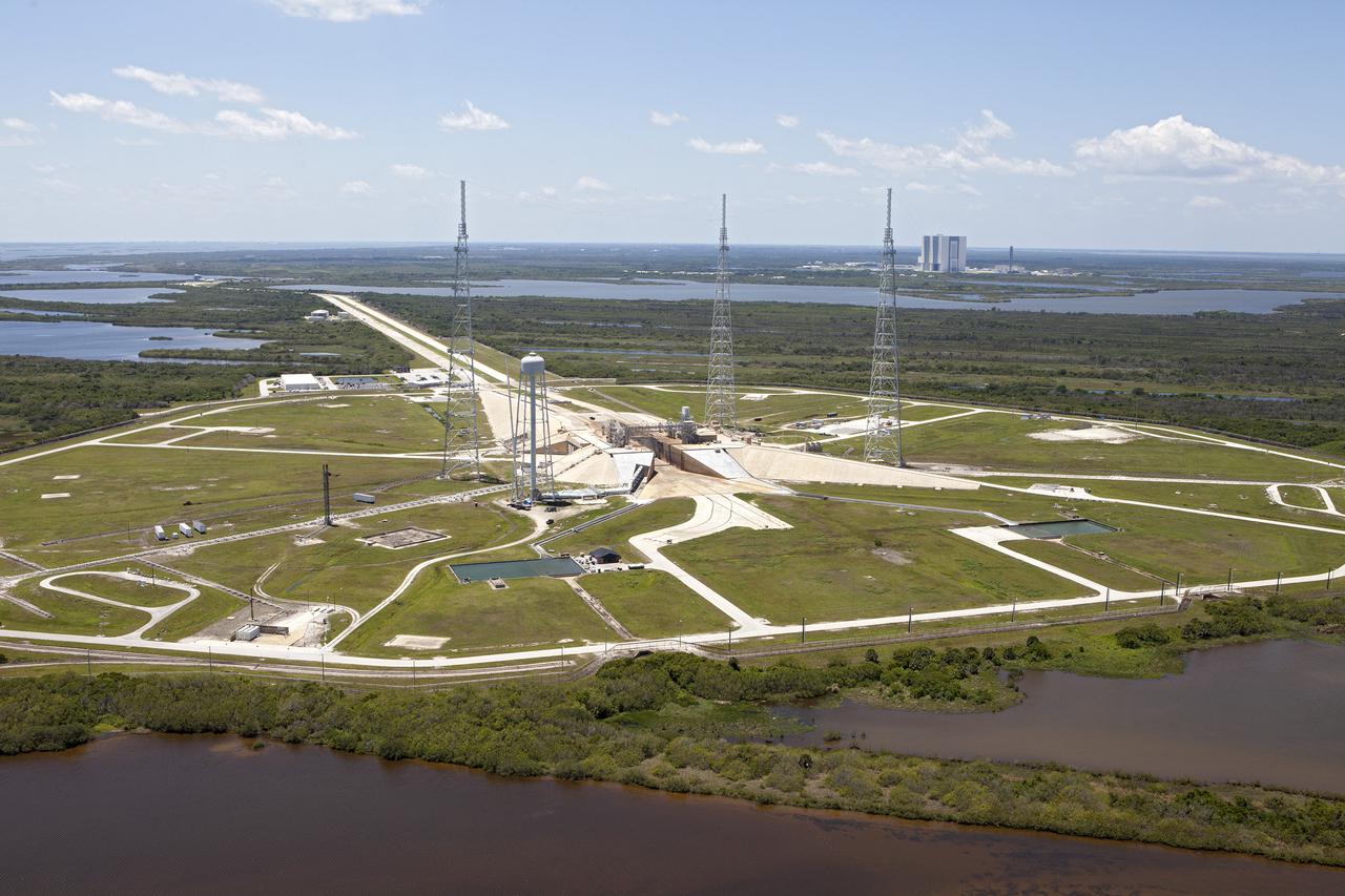 CAPE CANAVERAL, Fla. – An aerial view shows construction progress at Launch Pad 39B at NASA’s Kennedy Space Center in Florida. A new elevator has been constructed on the surface of the pad and the crawlerway leading up to the surface is being repaired. Repairs also are being made to the crawler track panels and catacomb roof below on either side of the flame trench. Also in view are the water tower and the three tall lightning towers that surround the pad. To the right, in the background is the Vehicle Assembly Building.  Upgrades are underway at Pad B and other facilities in the Launch Complex 39 area. The Ground Systems Development and Operations, or GSDO, Program office at Kennedy is leading the center’s transformation from a historically government-only launch complex to a spaceport that can safely handle a variety of rockets and spacecraft, including NASA’s Space Launch System. For more information about GSDO, visit: http:__go.nasa.gov_groundsystems.  Photo credit: NASA_Kim Shiflett