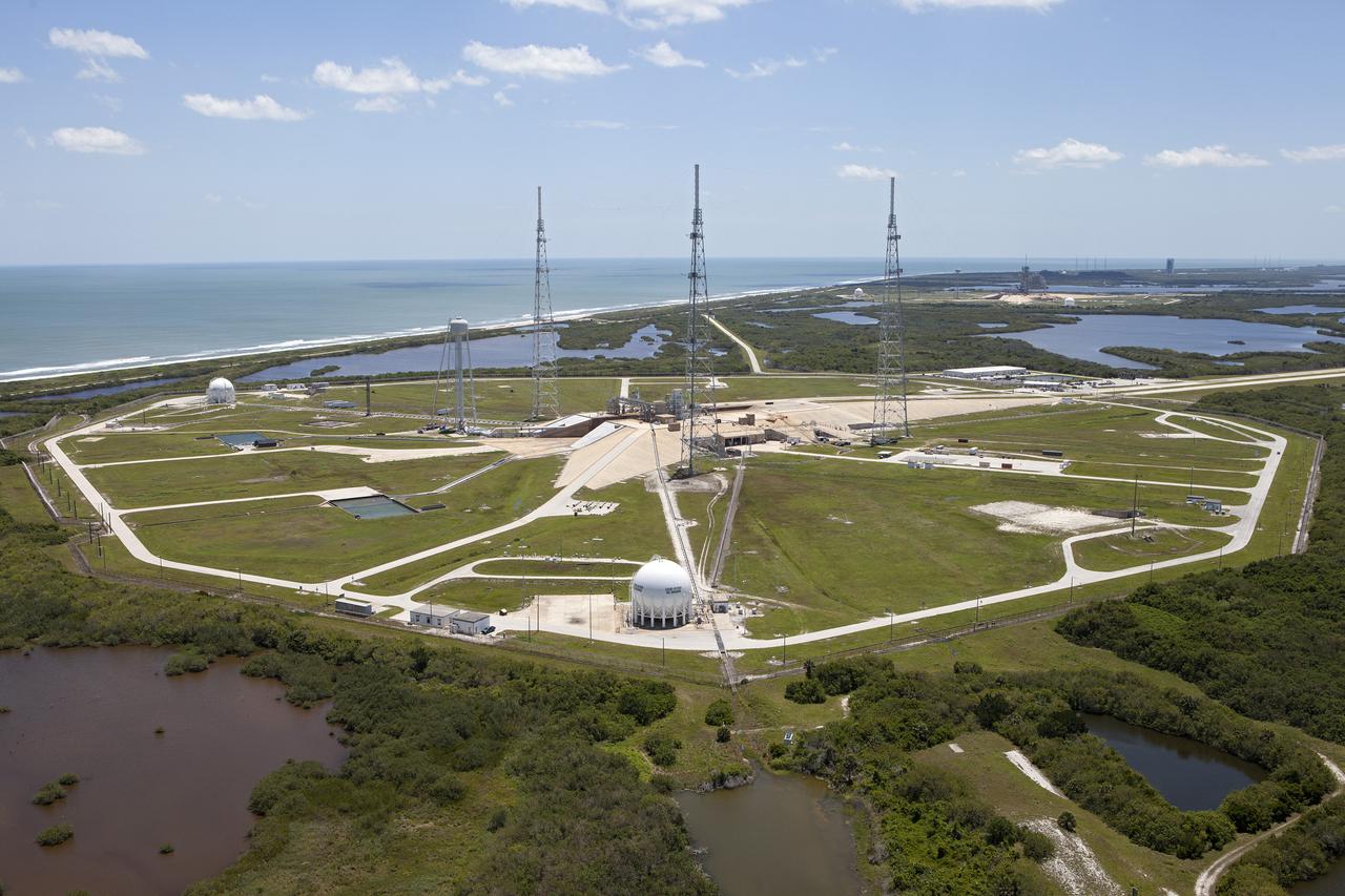 CAPE CANAVERAL, Fla. – An aerial view, from the west looking toward the east, shows the entire Launch Pad 39B area at NASA’s Kennedy Space Center in Florida. A new elevator has been constructed on the surface of the pad and the crawlerway leading up to the surface is being repaired. Repairs also are being made to the crawler track panels and catacomb roof below on either side of the flame trench. Also in view are the water tower and the three tall lightning towers that surround the pad. To the east is the Atlantic Ocean.  Upgrades are underway at Pad B and other facilities in the Launch Complex 39 area. The Ground Systems Development and Operations, or GSDO, Program office at Kennedy is leading the center’s transformation from a historically government-only launch complex to a spaceport that can safely handle a variety of rockets and spacecraft, including NASA’s Space Launch System. For more information about GSDO, visit: http:__go.nasa.gov_groundsystems.  Photo credit: NASA_Kim Shiflett