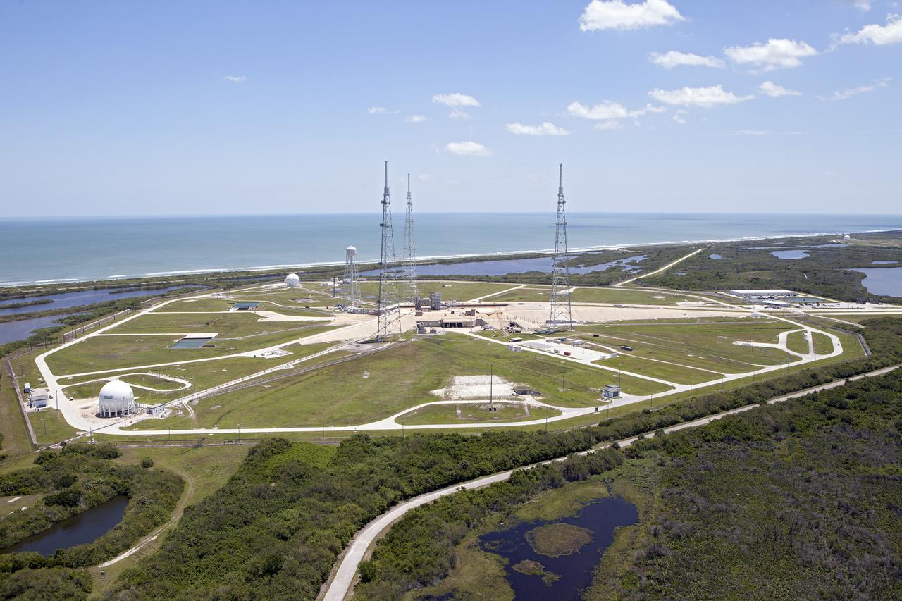 CAPE CANAVERAL, Fla. – An aerial view, from the west looking toward the east, shows the entire Launch Pad 39B area at NASA’s Kennedy Space Center in Florida. A new elevator has been constructed on the surface of the pad and the crawlerway leading up to the surface is being repaired. Repairs also are being made to the crawler track panels and catacomb roof below on either side of the flame trench. Also in view are the water tower and the three tall lightning towers that surround the pad. To the east is the Atlantic Ocean.  Upgrades are underway at Pad B and other facilities in the Launch Complex 39 area. The Ground Systems Development and Operations, or GSDO, Program office at Kennedy is leading the center’s transformation from a historically government-only launch complex to a spaceport that can safely handle a variety of rockets and spacecraft, including NASA’s Space Launch System. For more information about GSDO, visit: http:__go.nasa.gov_groundsystems.  Photo credit: NASA_Kim Shiflett