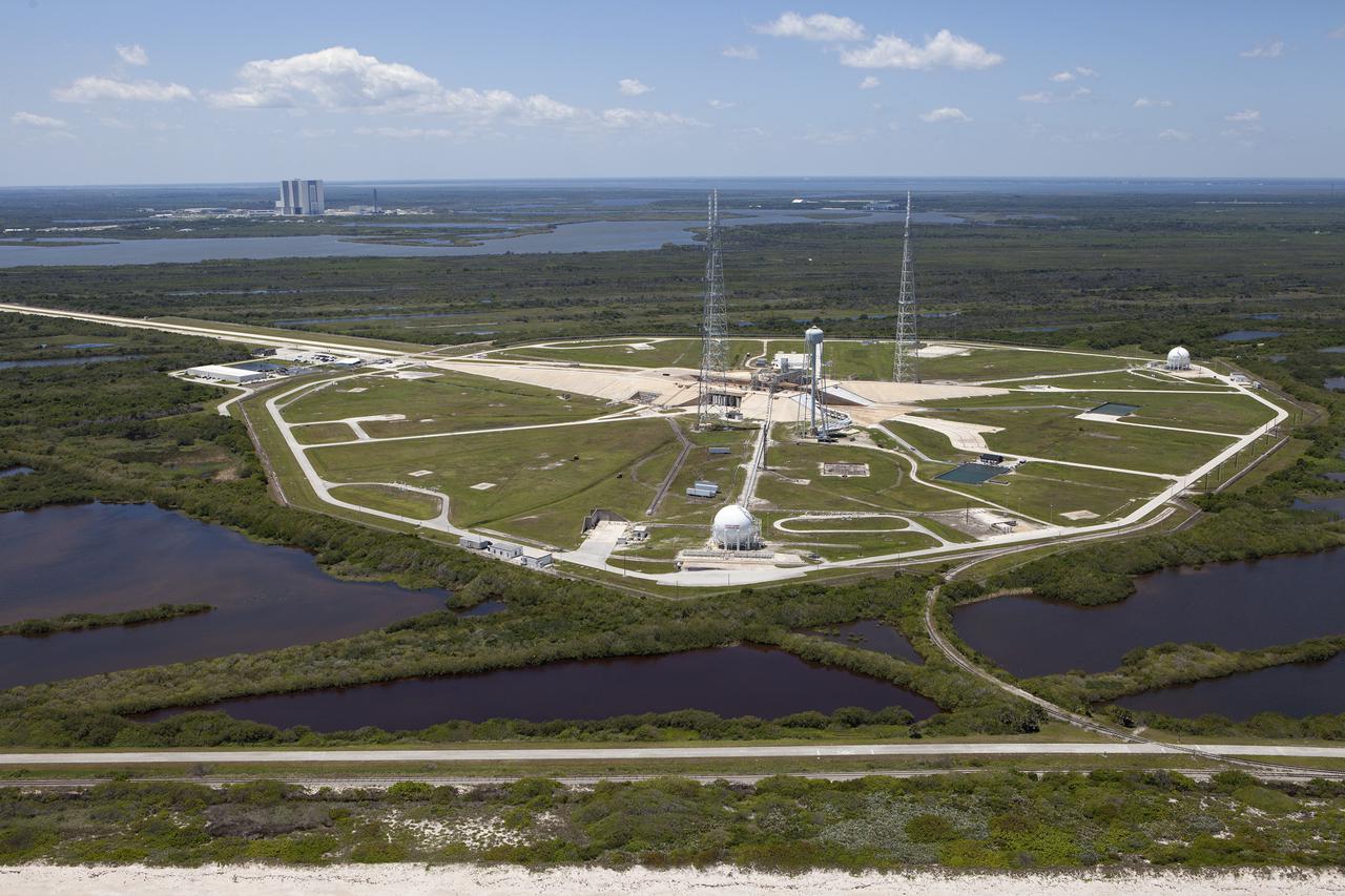 CAPE CANAVERAL, Fla. – An aerial view, from the east looking toward the west, shows the entire Launch Pad 39B area at NASA’s Kennedy Space Center in Florida. A new elevator has been constructed on the surface of the pad and the crawlerway leading up to the surface is being repaired. Repairs also are being made to the crawler track panels and catacomb roof below on either side of the flame trench. Also in view are the water tower and the three tall lightning towers that surround the pad. To the left, in the background is the Vehicle Assembly Building.  Upgrades are underway at Pad B and other facilities in the Launch Complex 39 area. The Ground Systems Development and Operations, or GSDO, Program office at Kennedy is leading the center’s transformation from a historically government-only launch complex to a spaceport that can safely handle a variety of rockets and spacecraft, including NASA’s Space Launch System. For more information about GSDO, visit: http:__go.nasa.gov_groundsystems.  Photo credit: NASA_Kim Shiflett