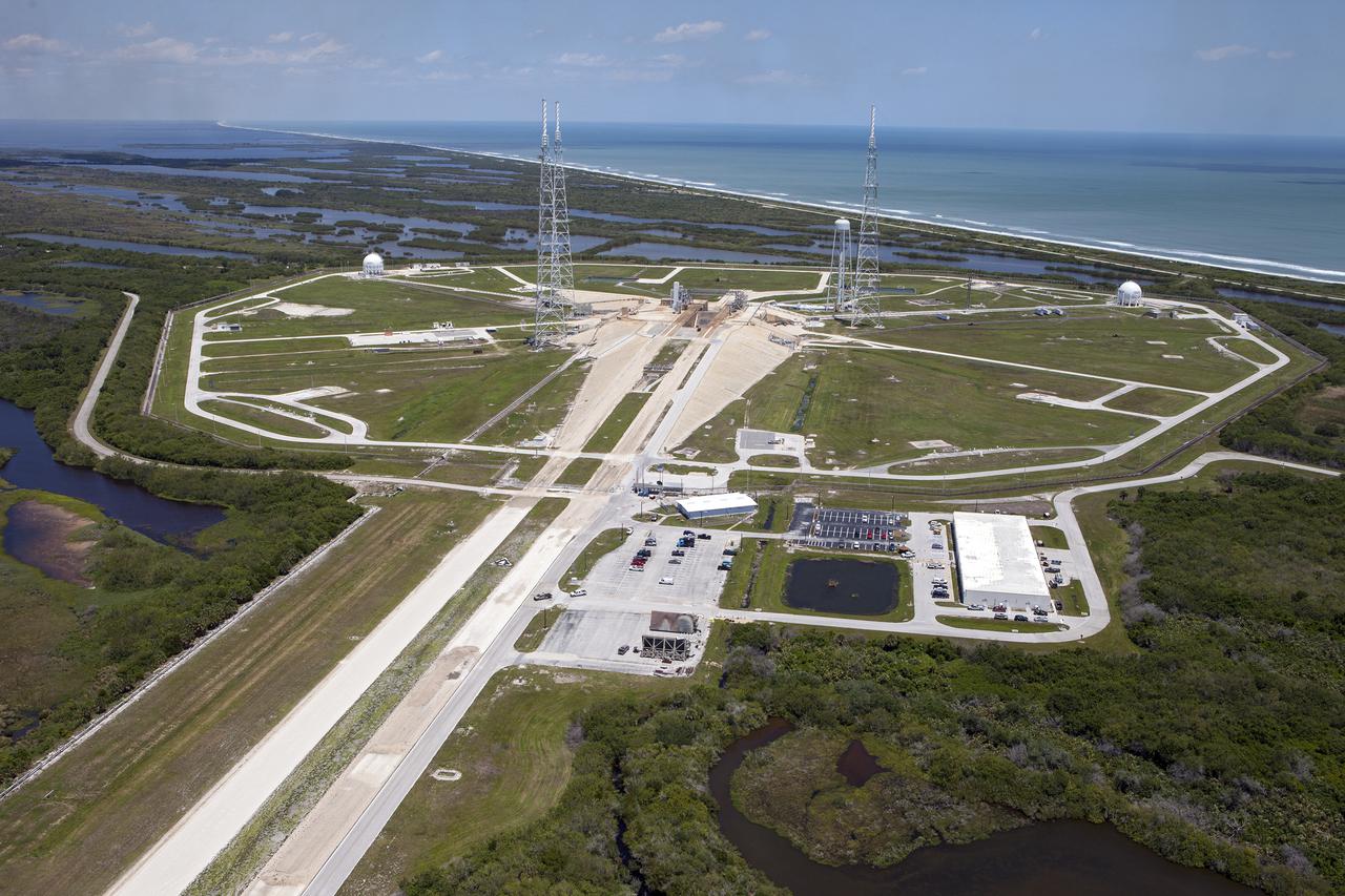 CAPE CANAVERAL, Fla. – An aerial view, from the southwest looking toward the northeast, shows the entire Launch Pad 39B area at NASA’s Kennedy Space Center in Florida with the Atlantic Ocean in the background. A new elevator has been constructed on the surface of the pad and the crawlerway leading up to the surface is being repaired. Repairs also are being made to the crawler track panels and catacomb roof below on either side of the flame trench. Also in view are the water tower and the three tall lightning towers that surround the pad.   Upgrades are underway at Pad B and other facilities in the Launch Complex 39 area. The Ground Systems Development and Operations, or GSDO, Program office at Kennedy is leading the center’s transformation from a historically government-only launch complex to a spaceport that can safely handle a variety of rockets and spacecraft, including NASA’s Space Launch System. For more information about GSDO, visit: http:__go.nasa.gov_groundsystems.  Photo credit: NASA_Kim Shiflett