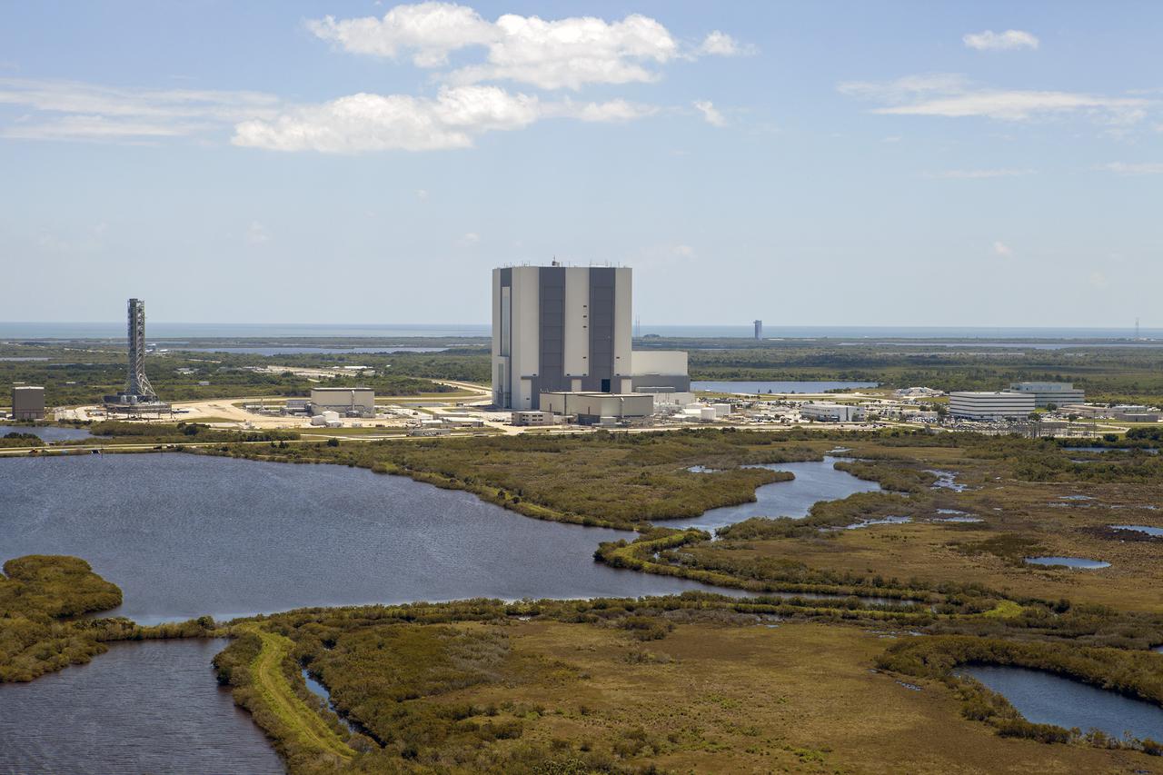 CAPE CANAVERAL, Fla. – An aerial view of the Vehicle Assembly Building and other buildings in the Launch Complex 39 area at NASA’s Kennedy Space Center in Florida. To the left is the mobile launcher that will be used to transport NASA’s Space Launch System rocket and the Orion crew capsule to Launch Pad 39B.   Upgrades are underway at Pad B and other facilities in the Launch Complex 39 area. The Ground Systems Development and Operations, or GSDO, Program office at Kennedy is leading the center’s transformation from a historically government-only launch complex to a spaceport that can safely handle a variety of rockets and spacecraft, including NASA’s Space Launch System. For more information about GSDO, visit: http:__go.nasa.gov_groundsystems.  Photo credit: NASA_Kim Shiflett