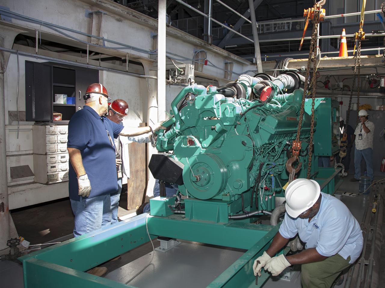 CAPE CANAVERAL, Fla. – Inside the Vehicle Assembly Building at NASA’s Kennedy Space Center in Florida, technicians prepare to install a new generator in crawler-transporter 1, or CT-1.    Work continues in high bay 3 to upgrade CT-1 as part of its general maintenance. CT-1 could be available to carry commercial launch vehicles to the launch pad. The crawler-transporters were used to carry the mobile launcher platform and space shuttle to Launch Complex 39 for space shuttle launches for 30 years.  Photo credit: NASA_Daniel Casper