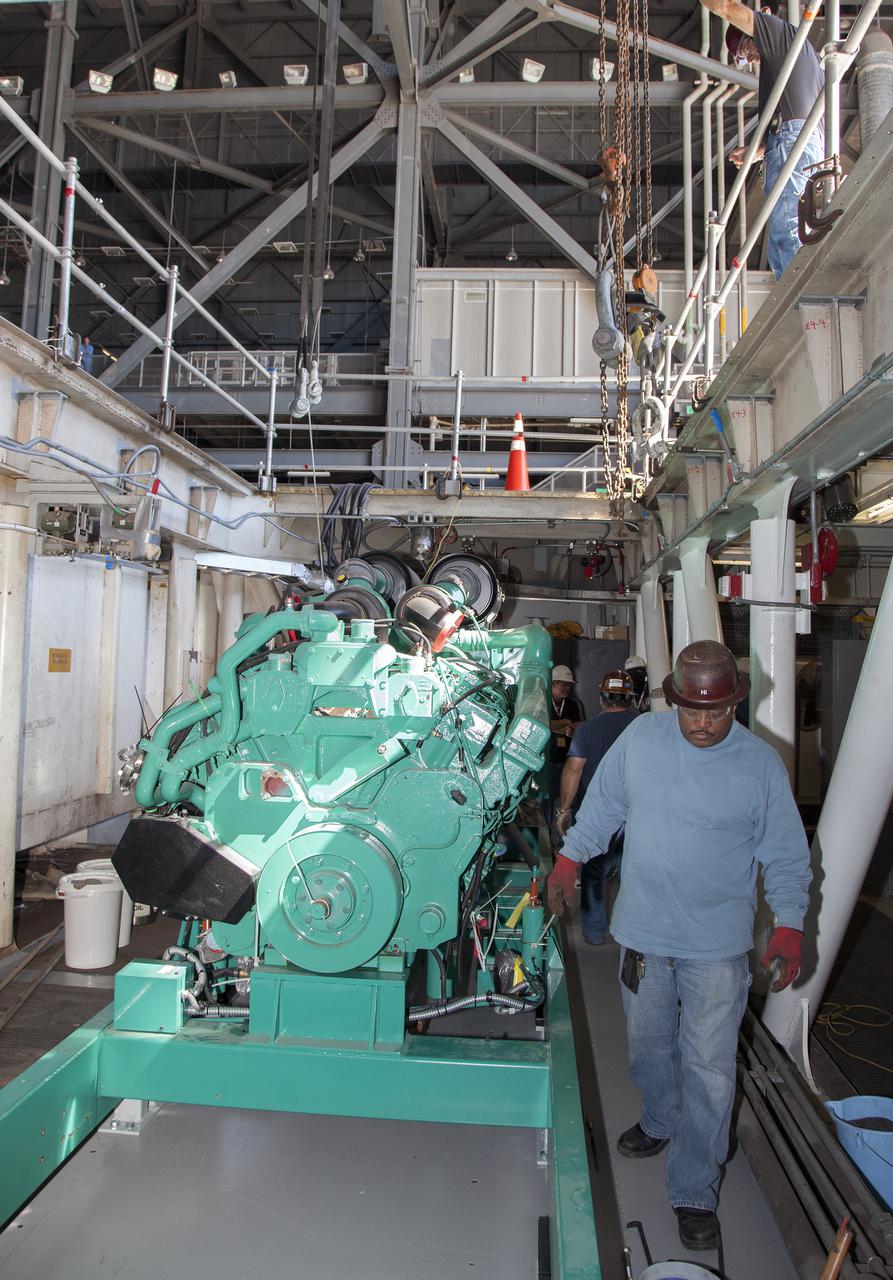 CAPE CANAVERAL, Fla. – Inside the Vehicle Assembly Building at NASA’s Kennedy Space Center in Florida, technicians prepare to install a new generator in crawler-transporter 1, or CT-1.    Work continues in high bay 3 to upgrade CT-1 as part of its general maintenance. CT-1 could be available to carry commercial launch vehicles to the launch pad. The crawler-transporters were used to carry the mobile launcher platform and space shuttle to Launch Complex 39 for space shuttle launches for 30 years.  Photo credit: NASA_Daniel Casper