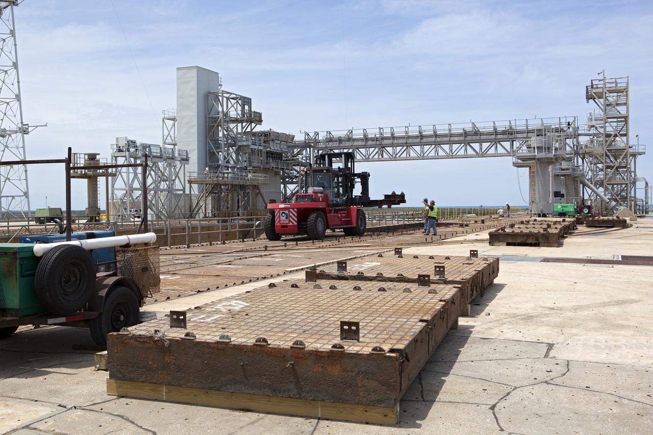 CAPE CANAVERAL, Fla. – At Launch Pad 39B at NASA’s Kennedy Space Center in Florida, removal of the crawler track panels on the pad’s surface is underway. The concrete surface beneath the panels and the catacomb roof below will be inspected for water damage and repaired.  There are 176 panels, each weighing about 30,000 pounds that will be removed. Launch Pad 39B is being refurbished to support NASA’s Space Launch System and other launch vehicles. The Ground Systems Development and Operations, or GSDO, Program office at Kennedy is leading the center’s transformation to safely handle a variety of rockets and spacecraft. For more information about GSDO, visit: http:__go.nasa.gov_groundsystems.  Photo credit: NASA_Dimitri Gerondidakis